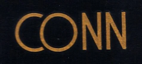 Close-up of the word 'CONN' in yellowish-orange text on a black background.