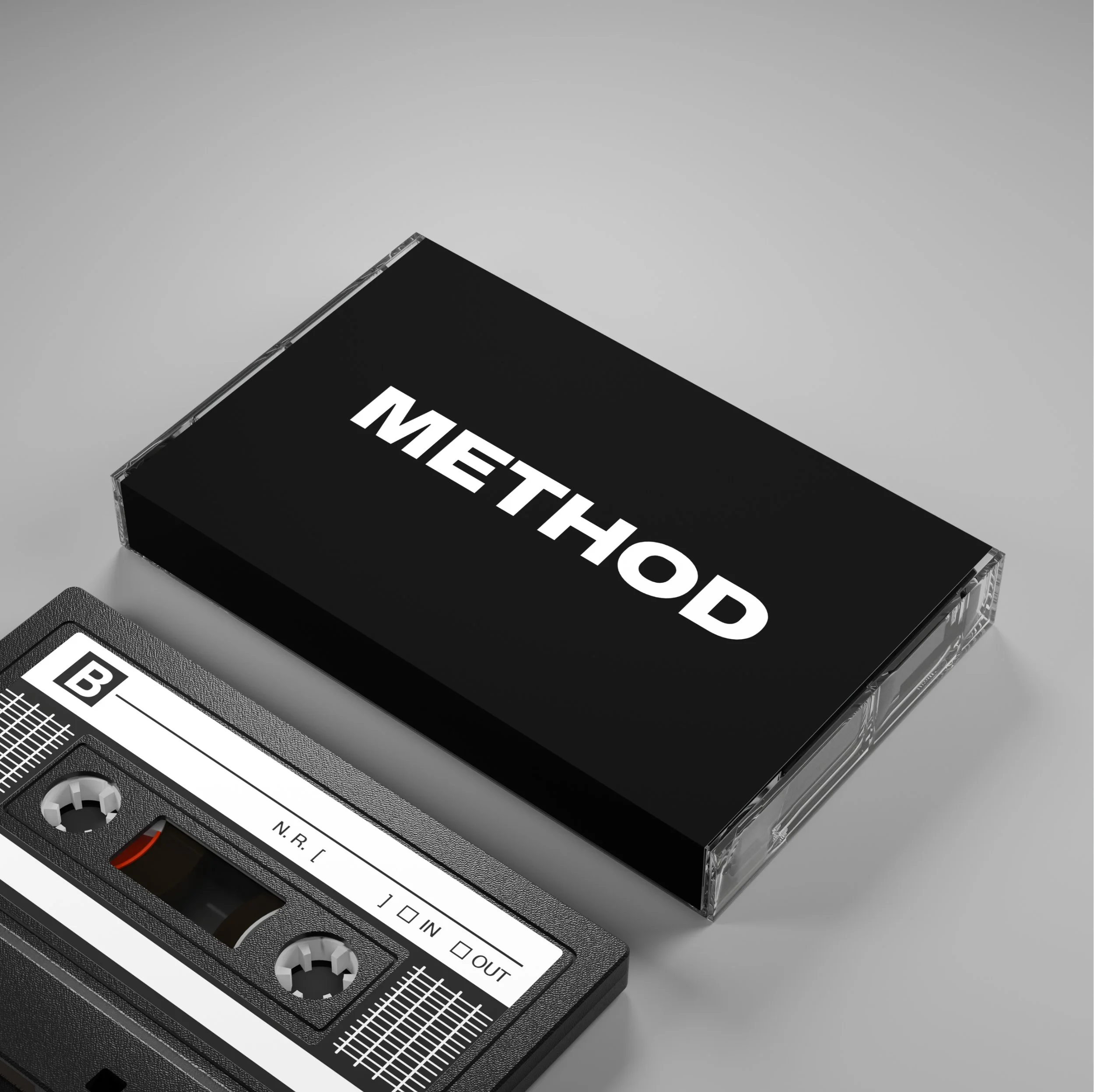 A cassette tape labeled 'METHOD' placed next to its plastic case on a gray surface.