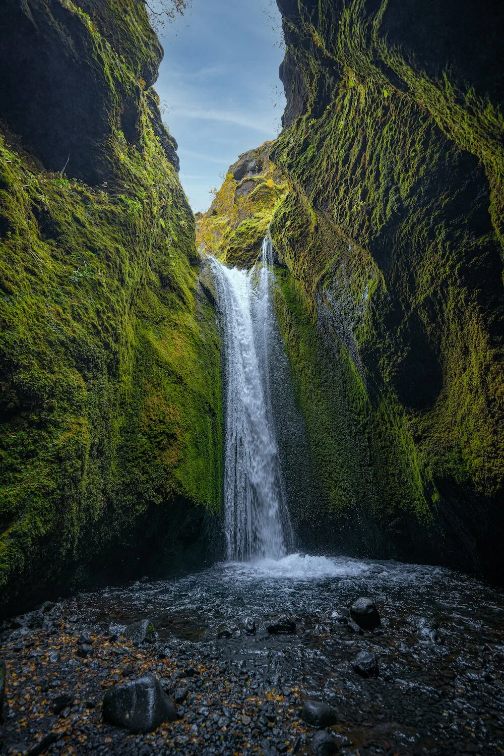Waterfall flowing through a narrow, moss-covered canyon, representing release and emotional movement