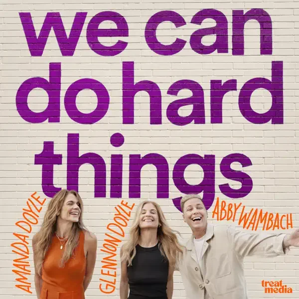 Three women smiling in front of a mural that reads "we can do hard things" with their names written vertically next to each. The women are identified as Amanda Doble, Glenn Dible, and Abby Wambach.