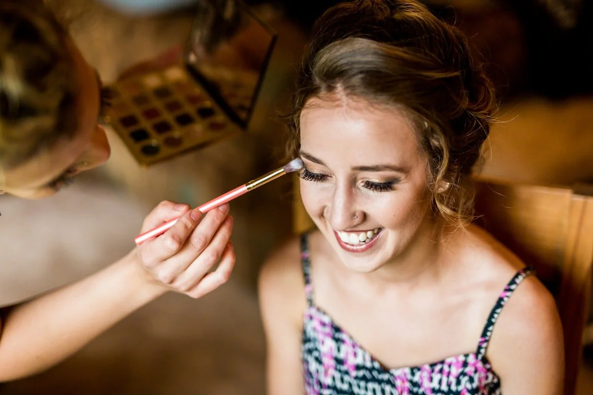 Bride getting makeup applied to her eyes before her wedding