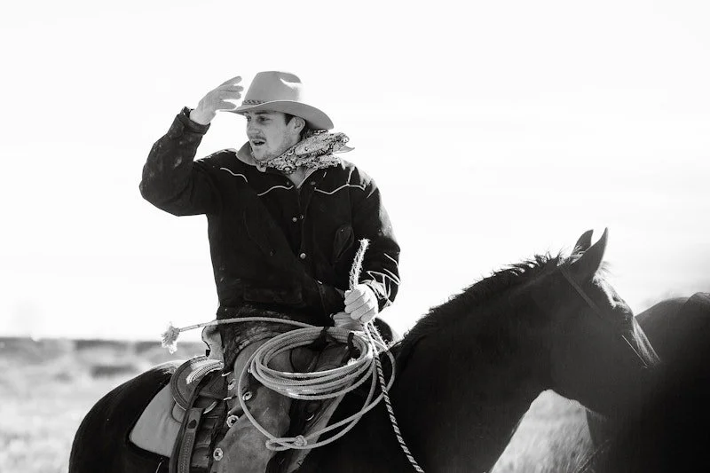 Cowboy riding on horse with lasso