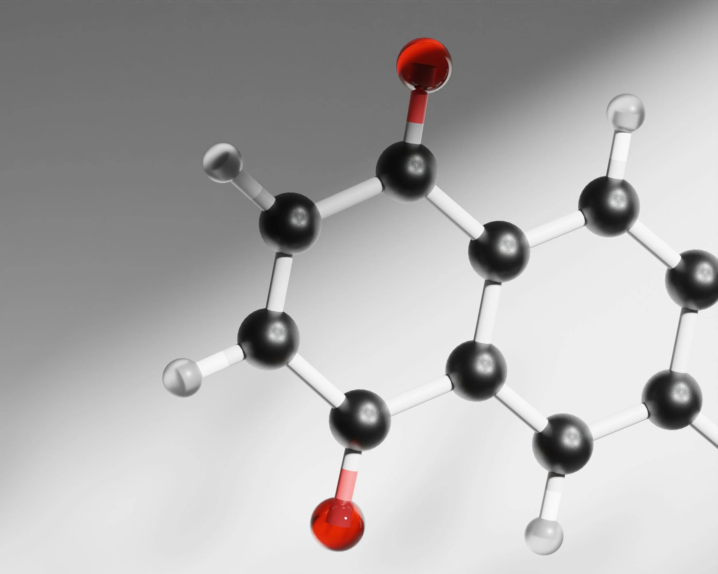 A molecular model with black, white, and red spheres connected by rods, representing a chemical structure, set against a gray background.