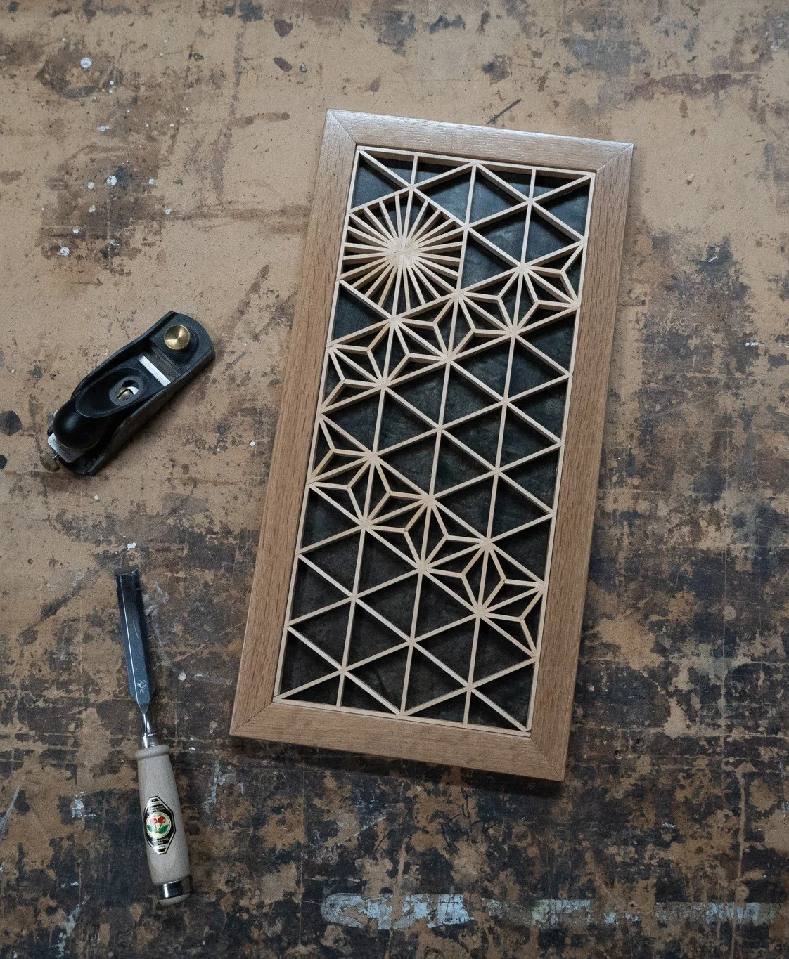 A wooden decorative panel with geometric star-like kumiko patterns.