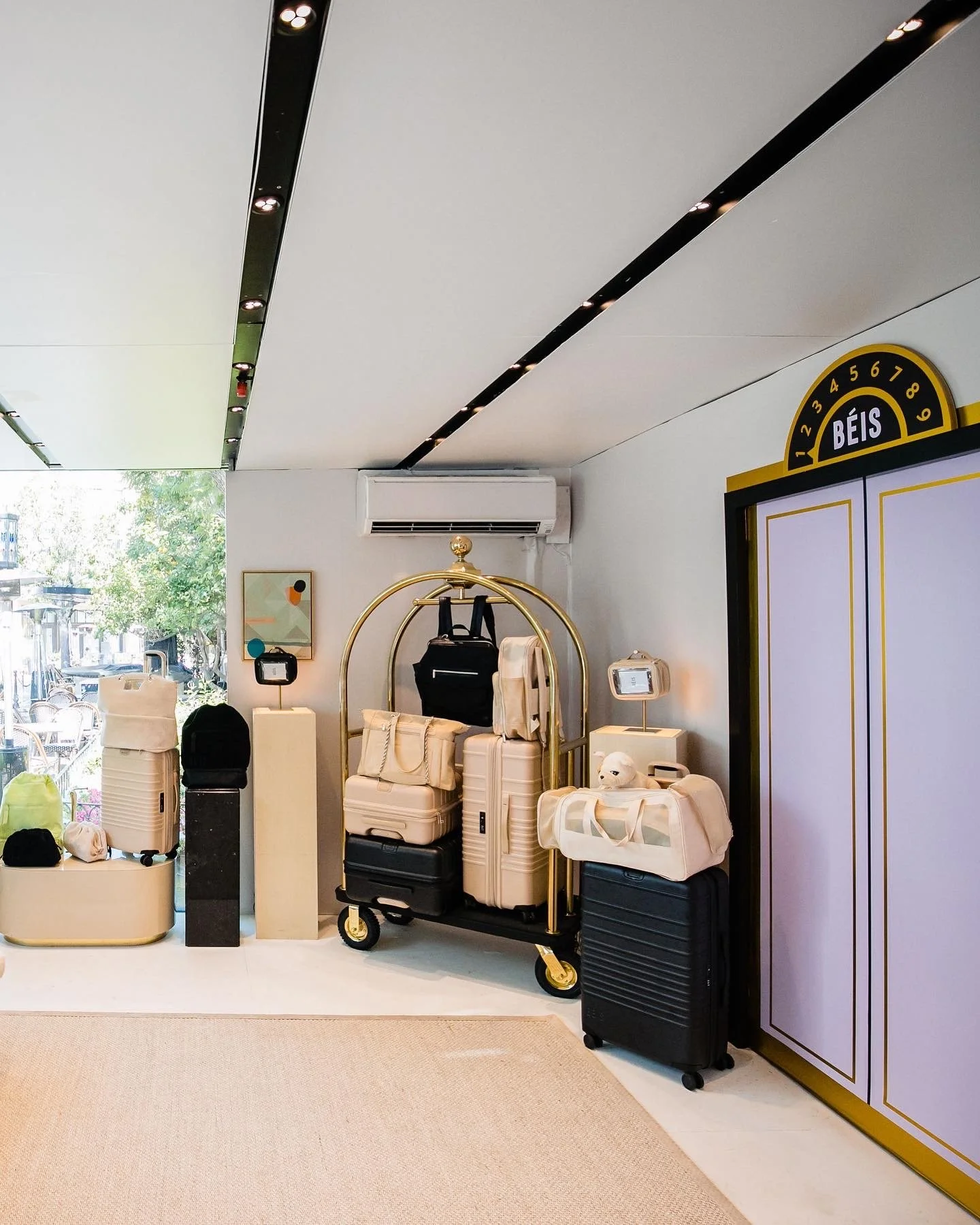Luggage and bags on a luggage cart near a reception desk at a hotel.