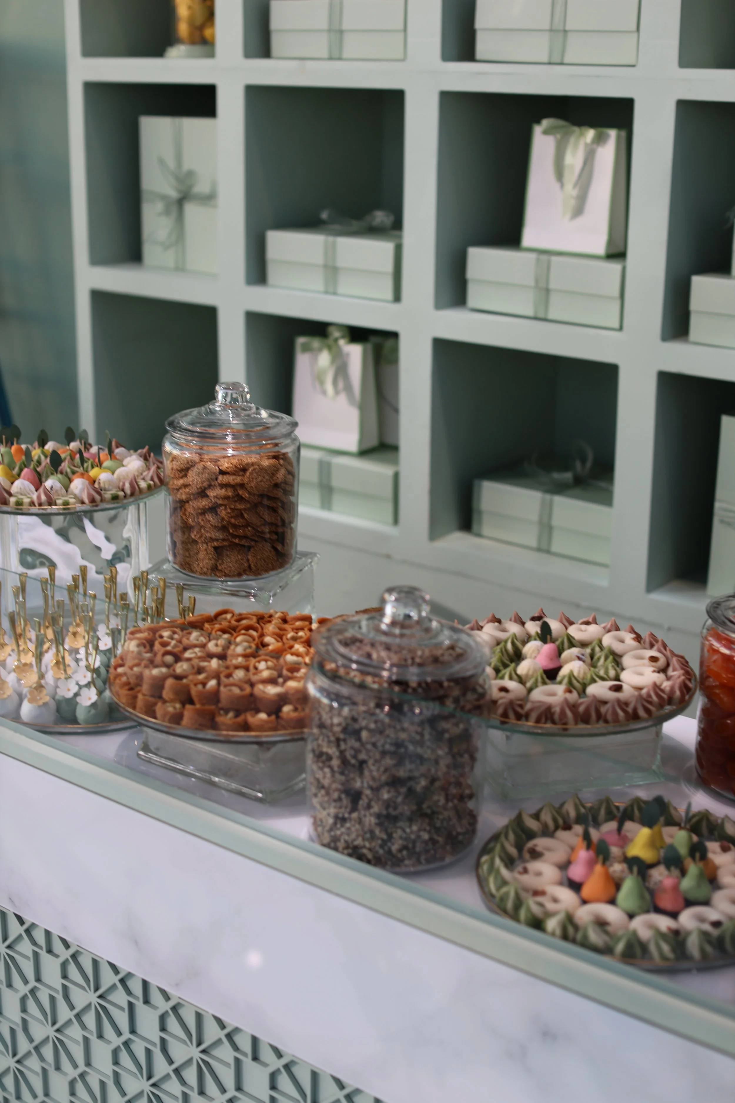 Display of assorted candies, cookies, and sweets on a table at a dessert buffet.