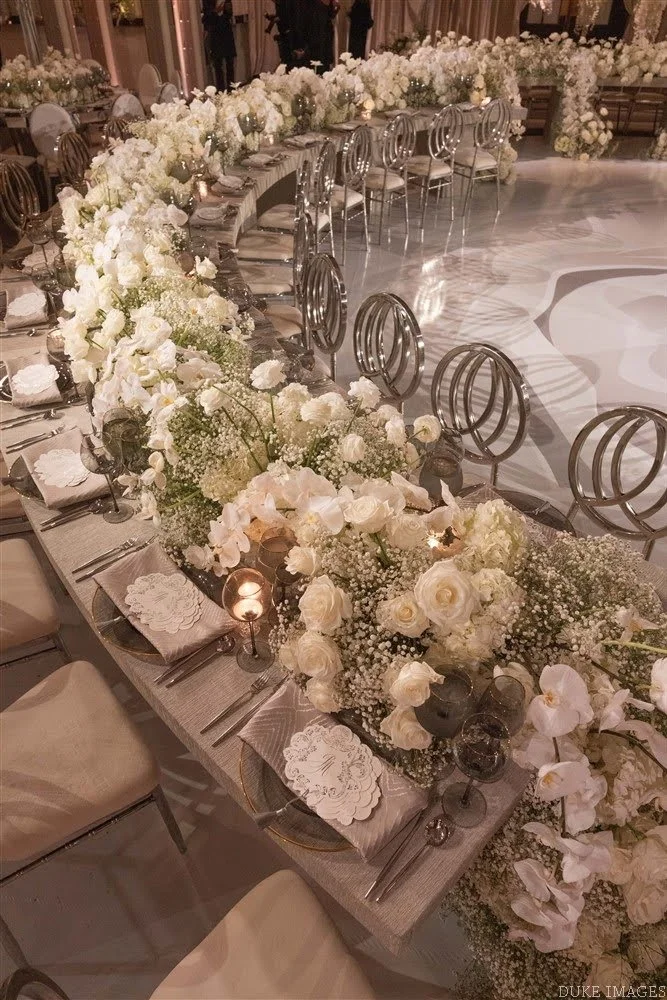 Elegant banquet table decorated with white flowers and candles for a celebration or wedding reception.