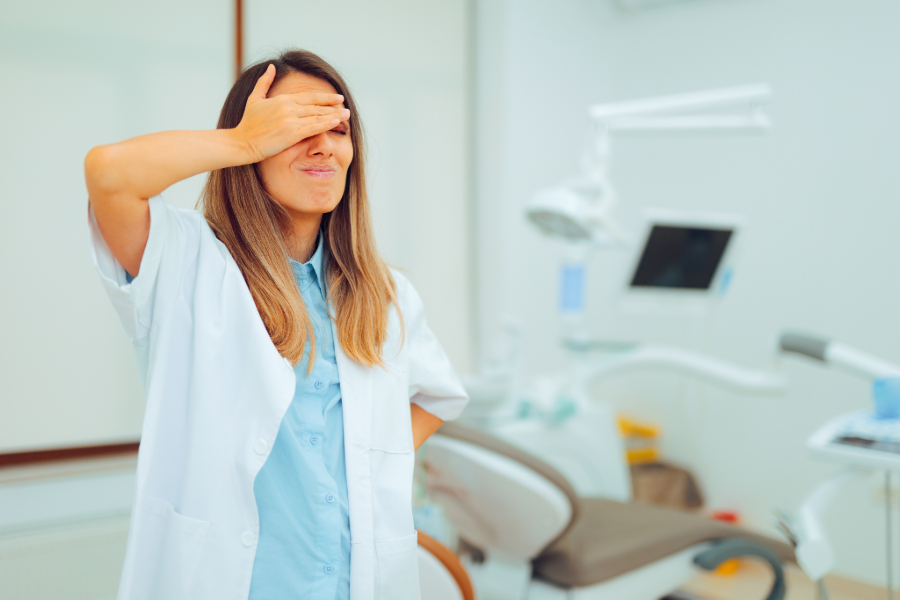 photograph of a female dental professional smacking her forehead in a dental exam room