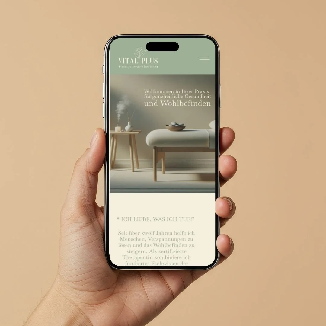 Hand hält ein Smartphone, das eine Webseite für ganzheitliche Gesundheit zeigt, mit einem minimalistischen Raum im Hintergrund.