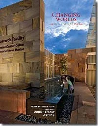 Exterior view of a modern architectural building with stone walls, labeled 'Research Facility' and 'Changing Worlds,' featuring a water feature and people interacting with the structure. The setting appears to be during the evening, with a clear sky.
