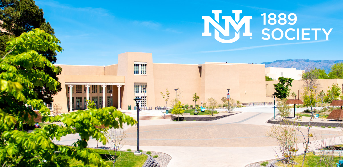 A modern campus building with a spacious plaza, trees, lamps, and mountain in the background, featuring the University of New Mexico logo and text '1889 Society' in the top right corner.