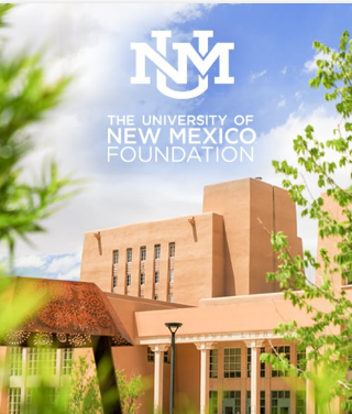 The University of New Mexico Foundation building with blue sky, green trees, and a lamppost visible in foreground.