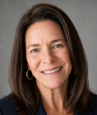 Close-up of a woman with shoulder-length dark hair, smiling, wearing gold hoop earrings and a dark top against a gray background.