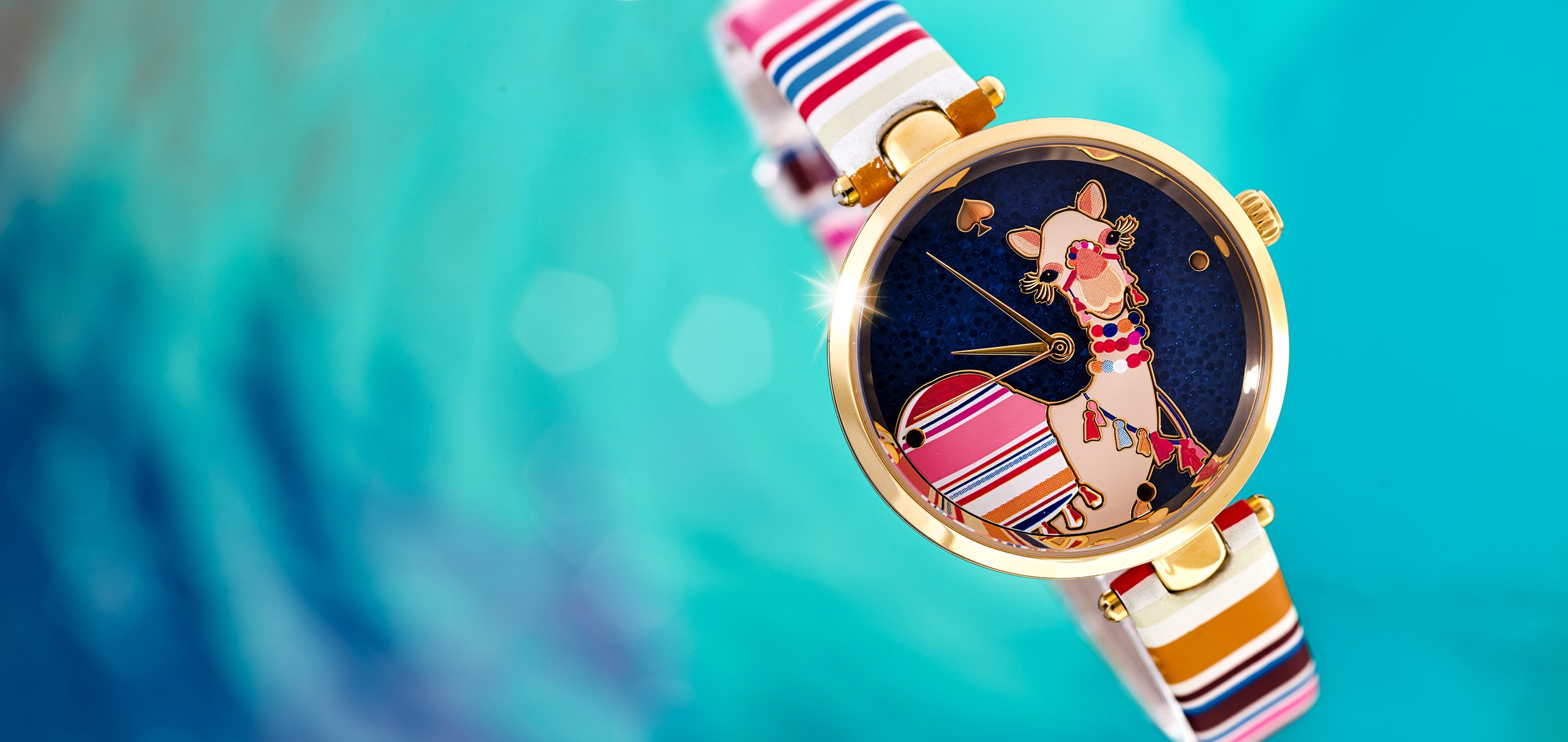 A colorful watch with a giraffe design on its face, featuring a striped strap in pink, red, white, and brown, against a blue background.