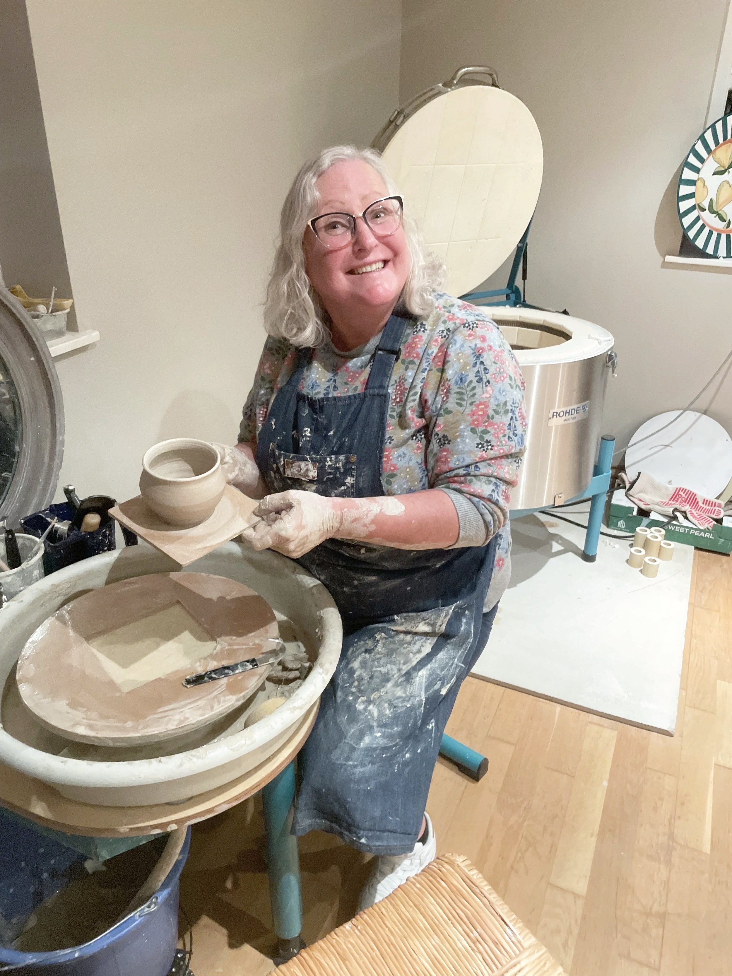 a happy female showing off her pottery following a successful pottery experience at One Wee Pot.