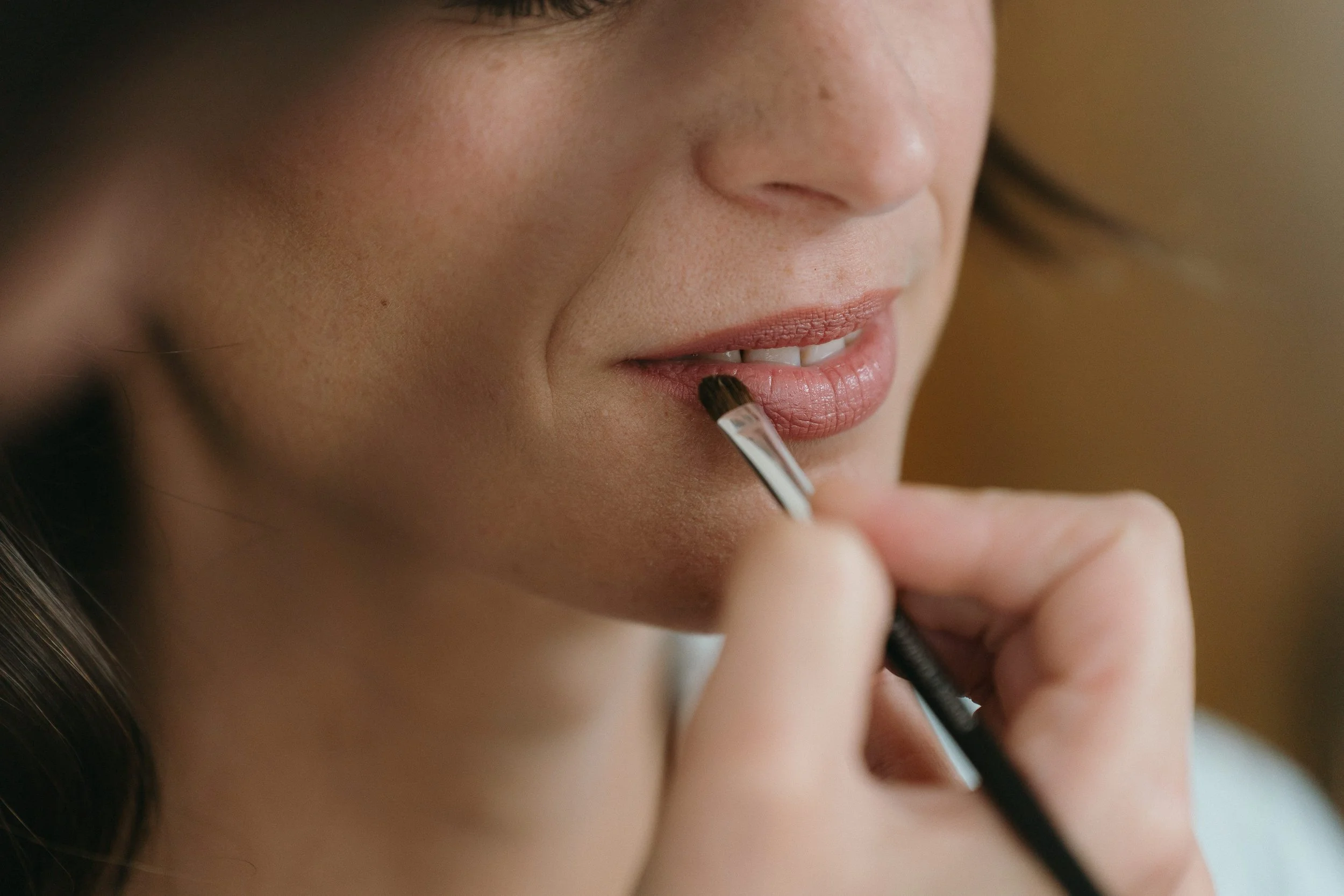 Audrey Langouët Maquilleuse professionnelle entrain d'appliquer un rouge à lèvre nude et naturel à une mariée