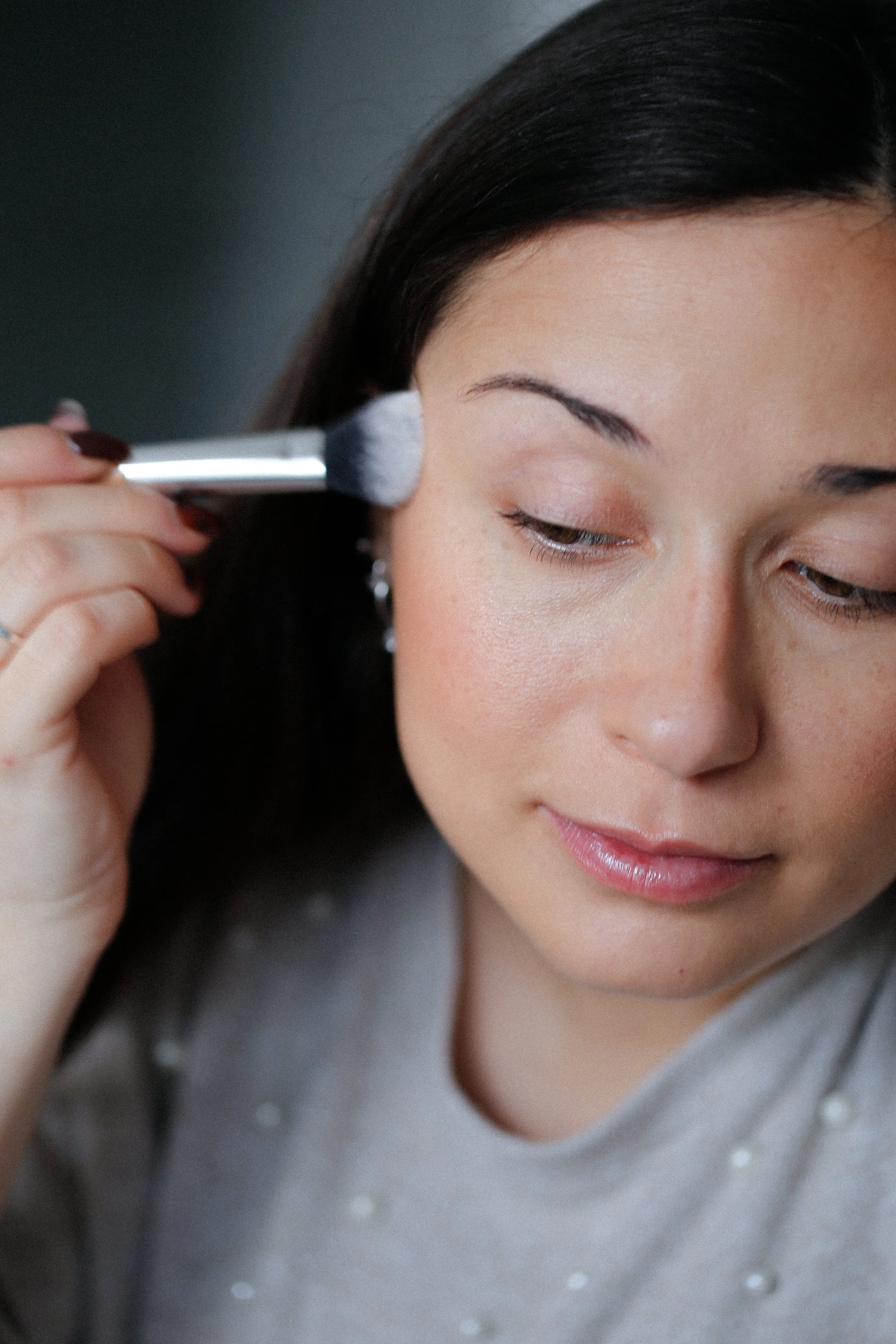 Jeune femme qui se maquiller lors d'un cours de maquillage avec une maquilleuse professionnelle en vendée, elle applique son blush au pinceau