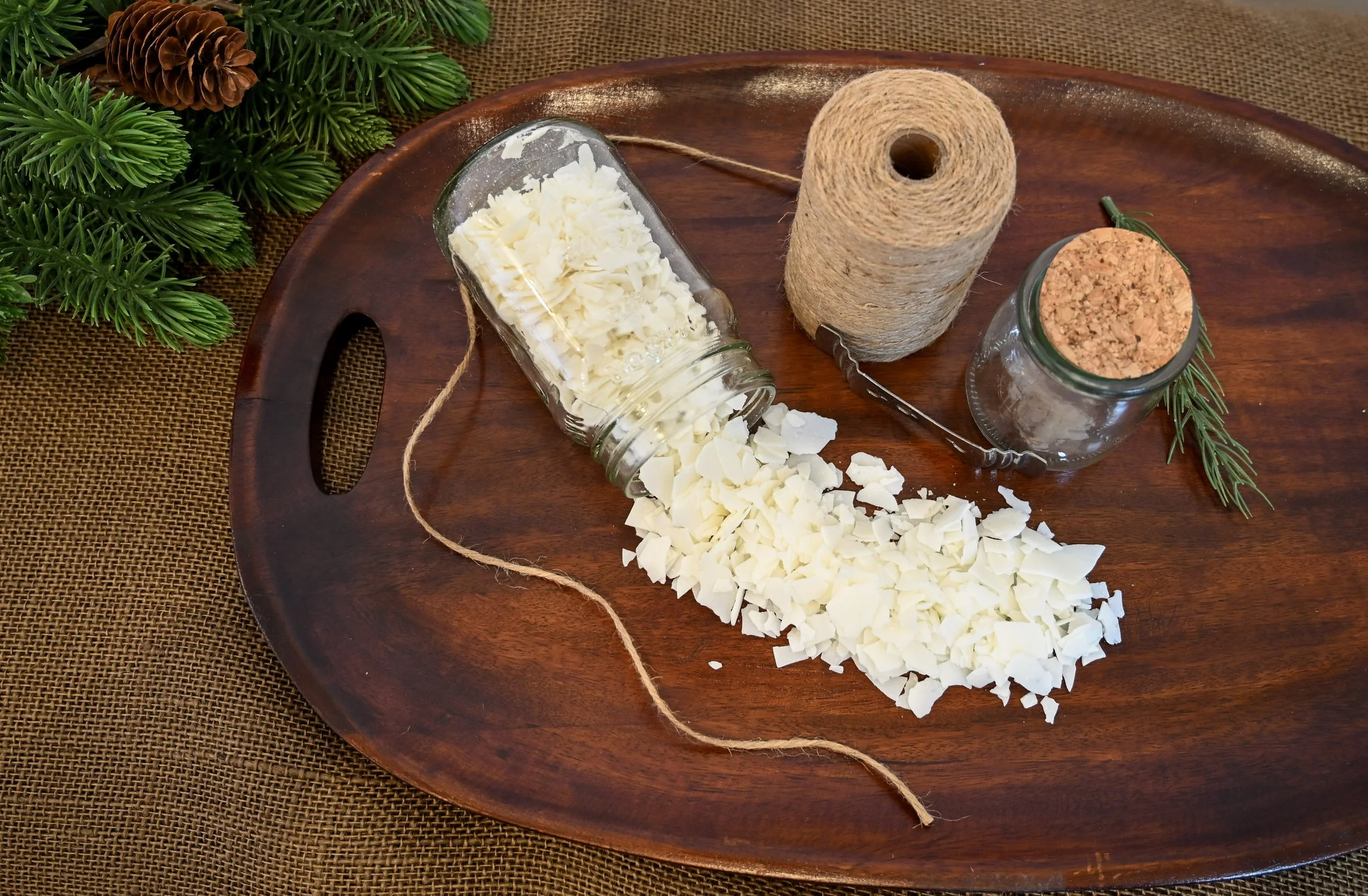 raw wax pouring onto board with twine and jar