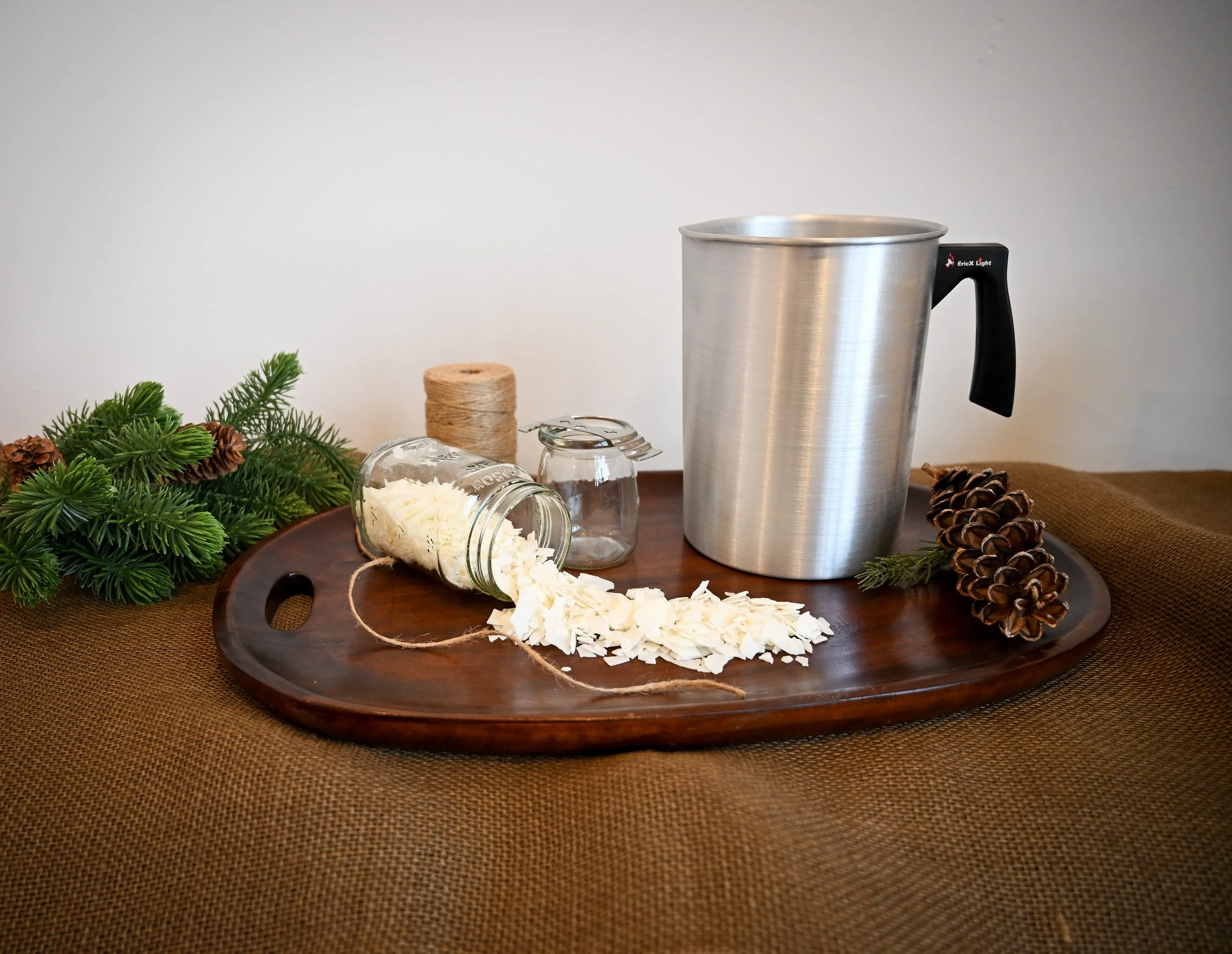 Raw wax pouring out of a jar with a pouring pitcher