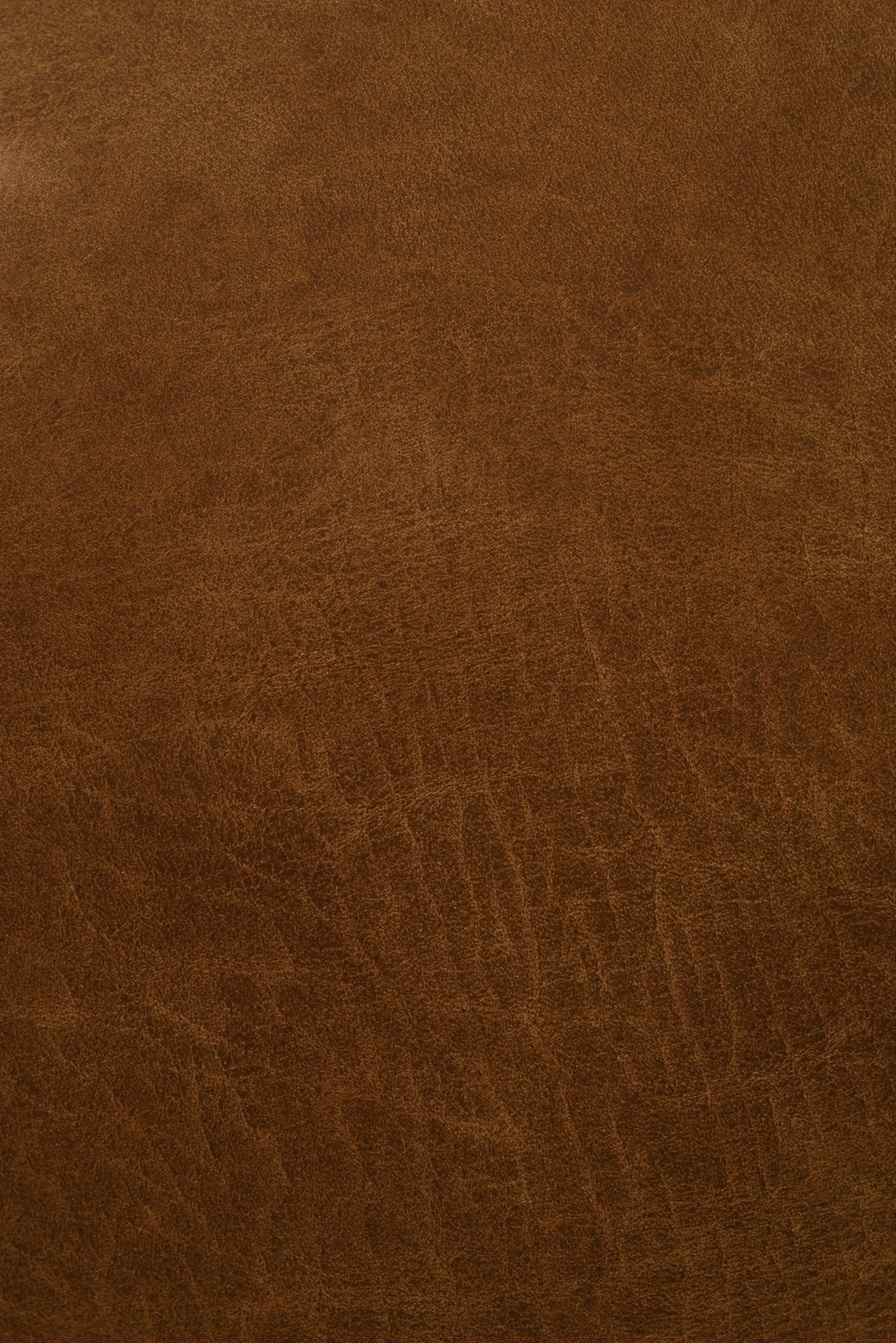 Close-up view of a brown leather surface with visible texture and grain.