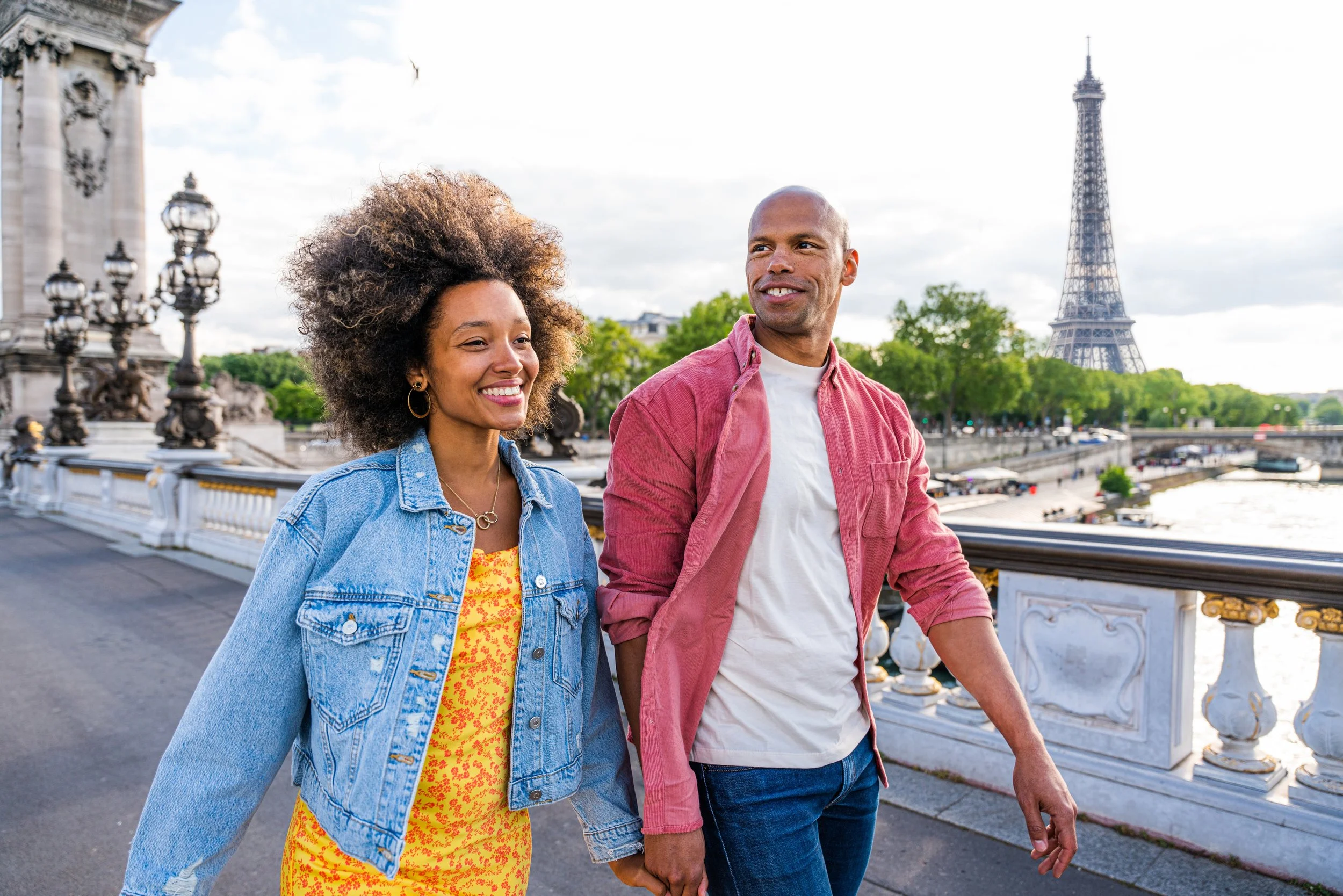 A middle-aged African American couple holding hands on a walk in Paris in the spring. 