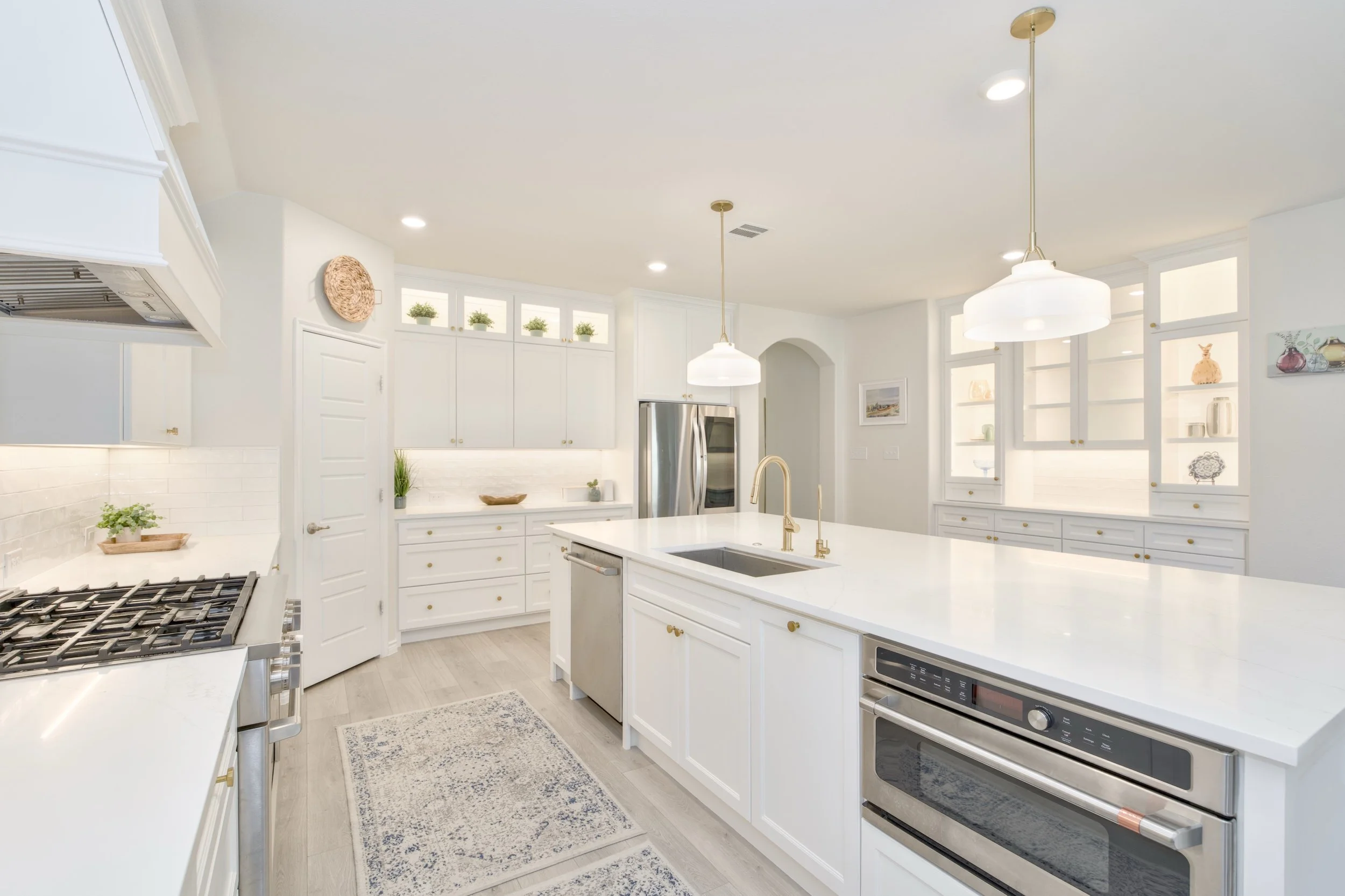 Kitchen island workspace features a GE Cafe Dishwasher with 3-racks; 32" Kraus undermount, stainless steel, single basin sink; paneled slide-out garbage station (right side of sink); and a built-in GE Cafe microwave with convection oven.