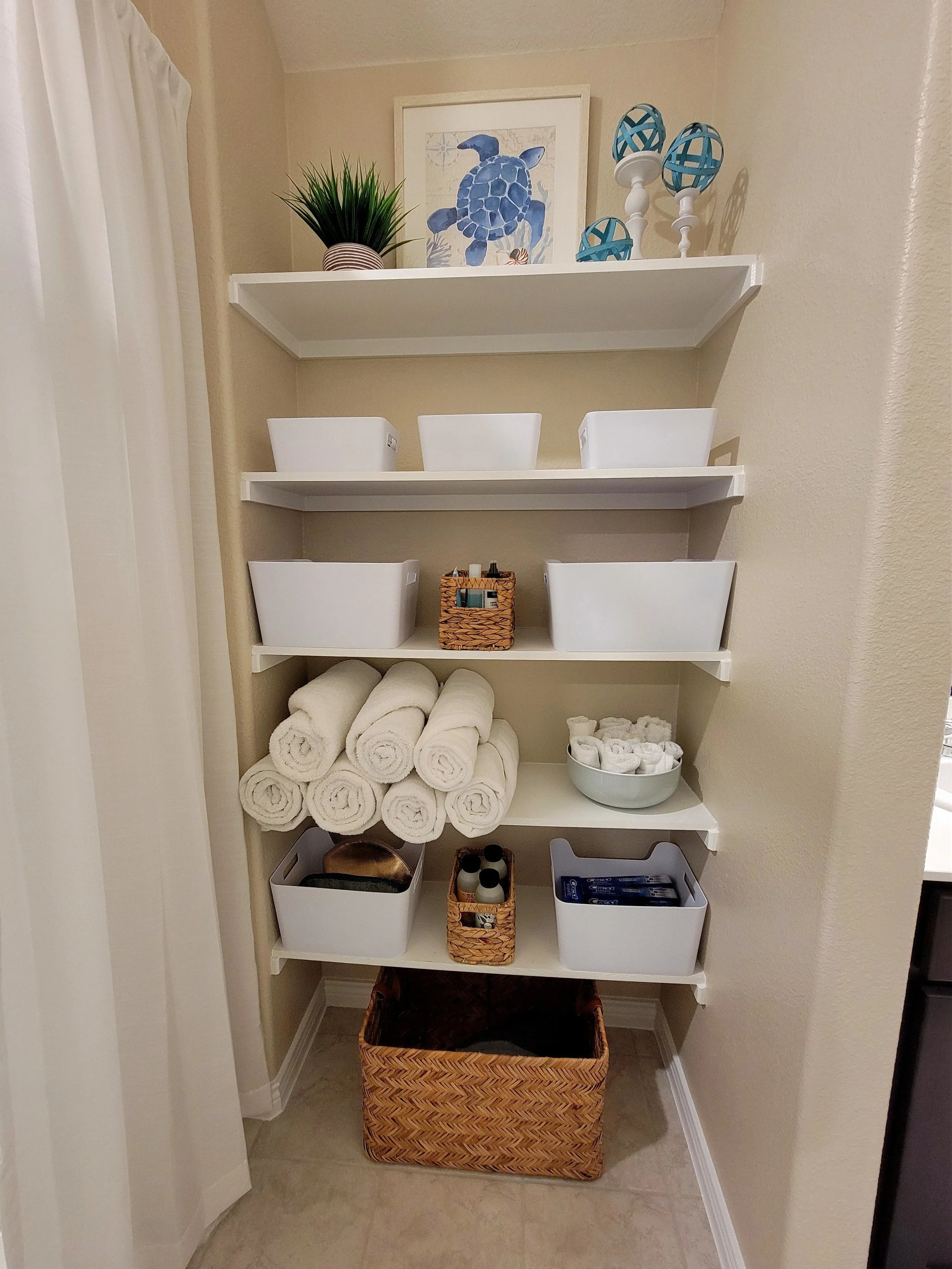 Styled builder-grade bathroom shelving for listing photos.