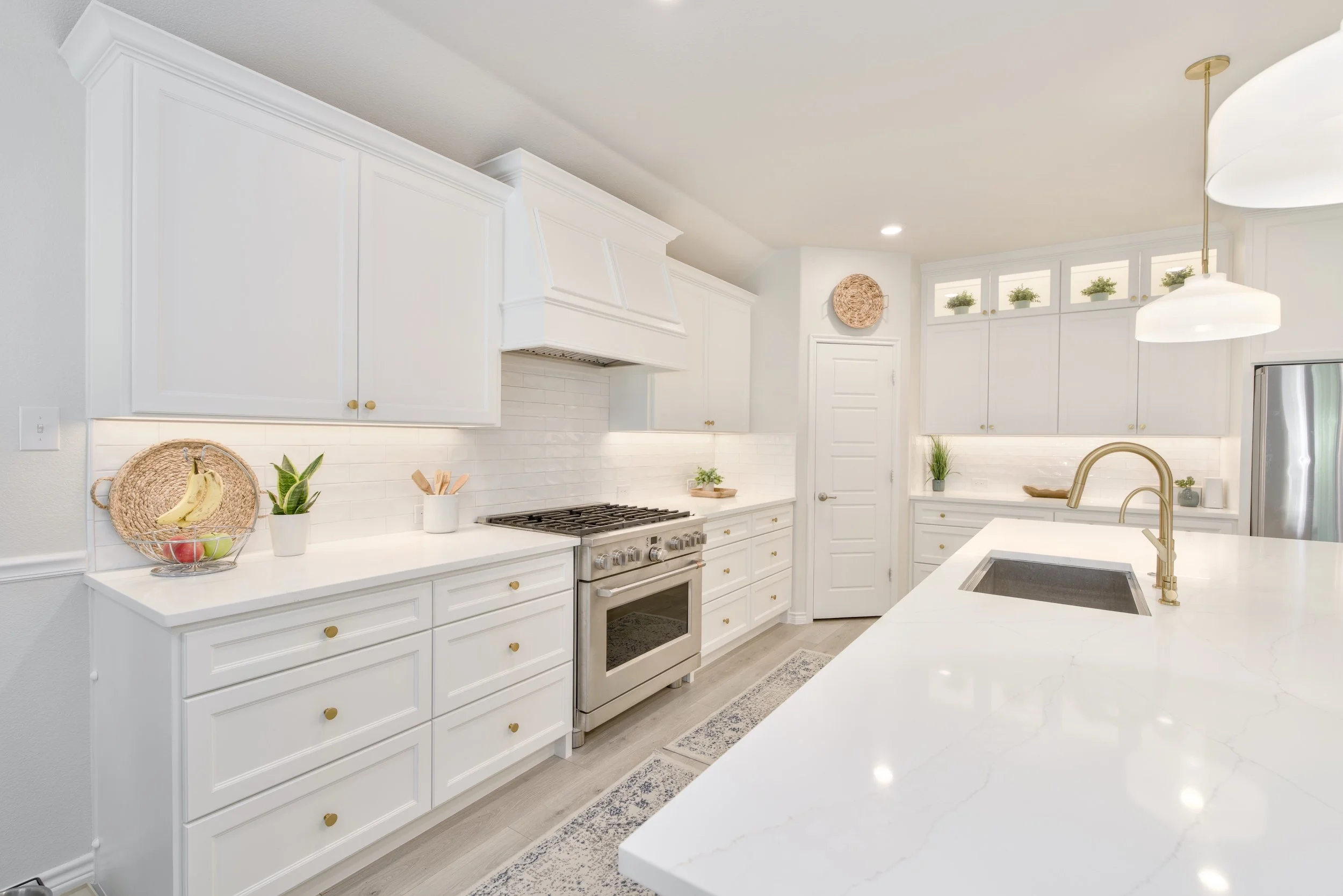 Kitchen reno (total gut except pantry) and design: After. Timeless white kitchen with contemporary touches in lighting, faucet, and cabinet hardware (brushed brass). This elegant kitchen also features soft-close custom birch cabinets and ample drawer