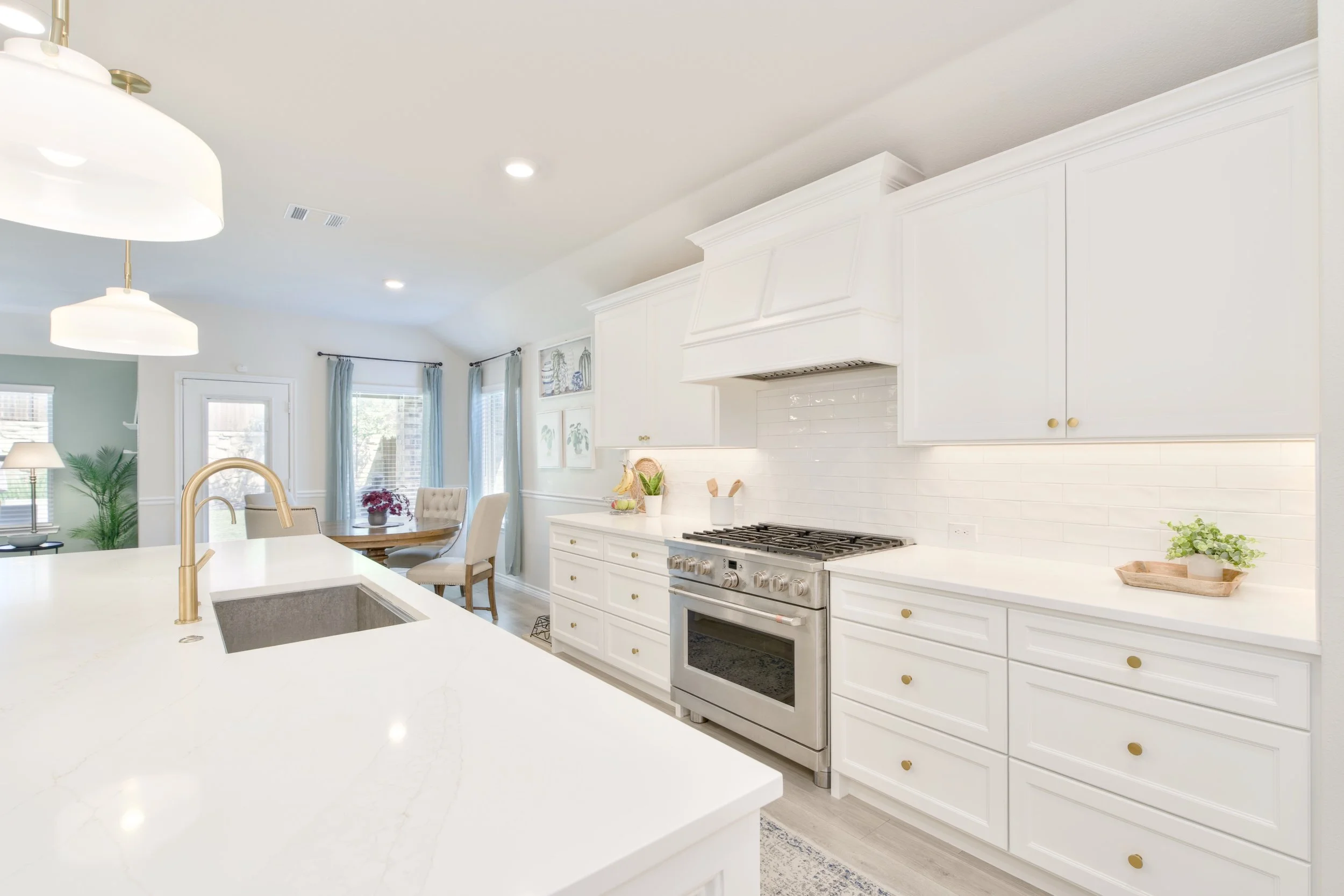 Kitchen features GE Cafe 36" Commercial- Style range with 6 burners (gas), and vent hood surrounded by custom cabinetry.