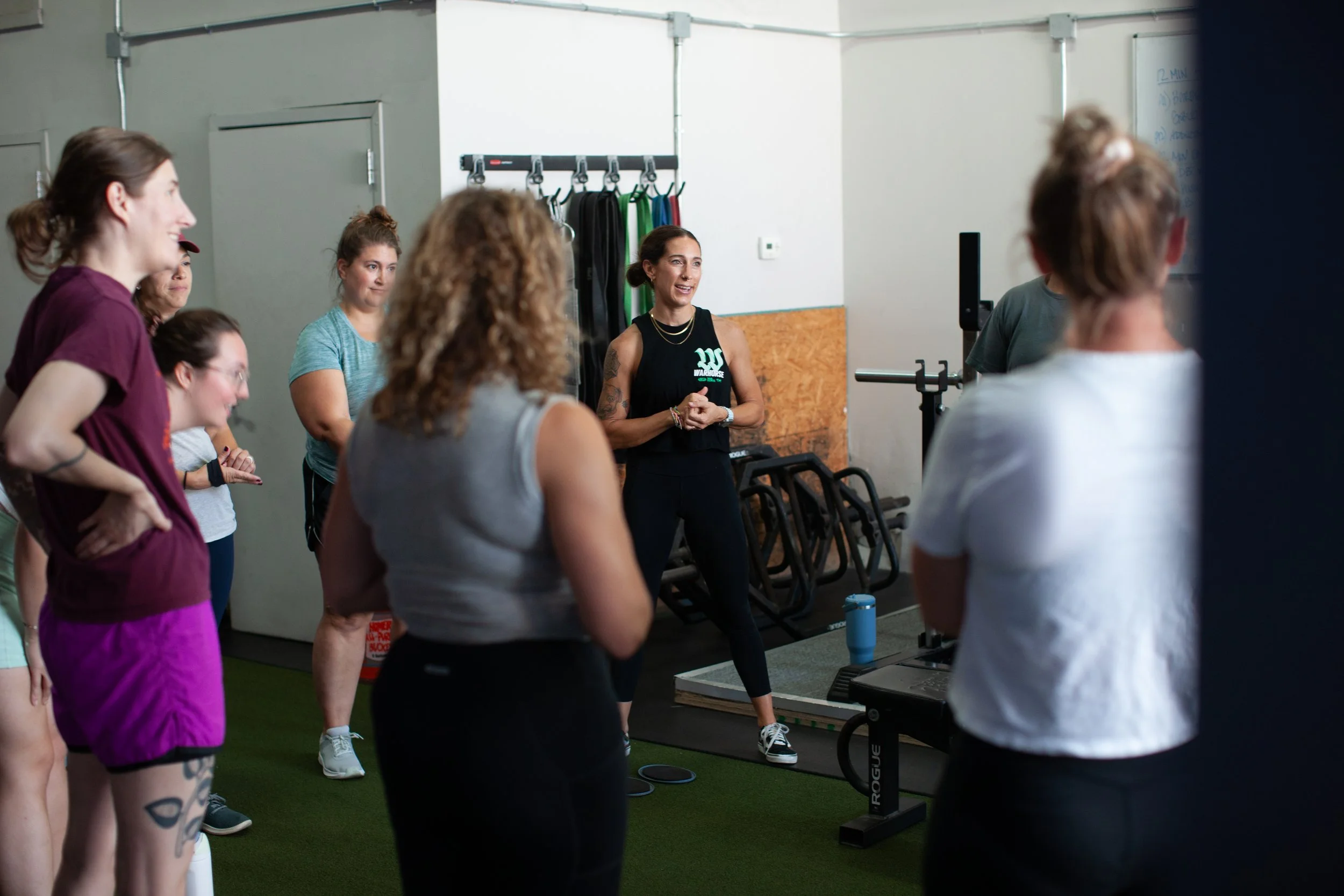 Women participating in a fitness class led by an instructor in a gym.