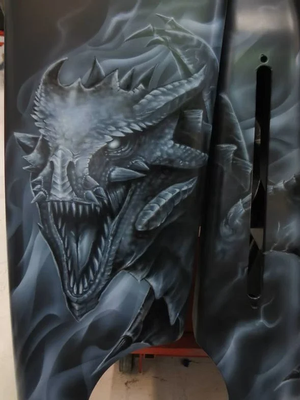 Black hoodie featuring a detailed grayscale illustration of a dragon's fierce head with sharp teeth and horns.