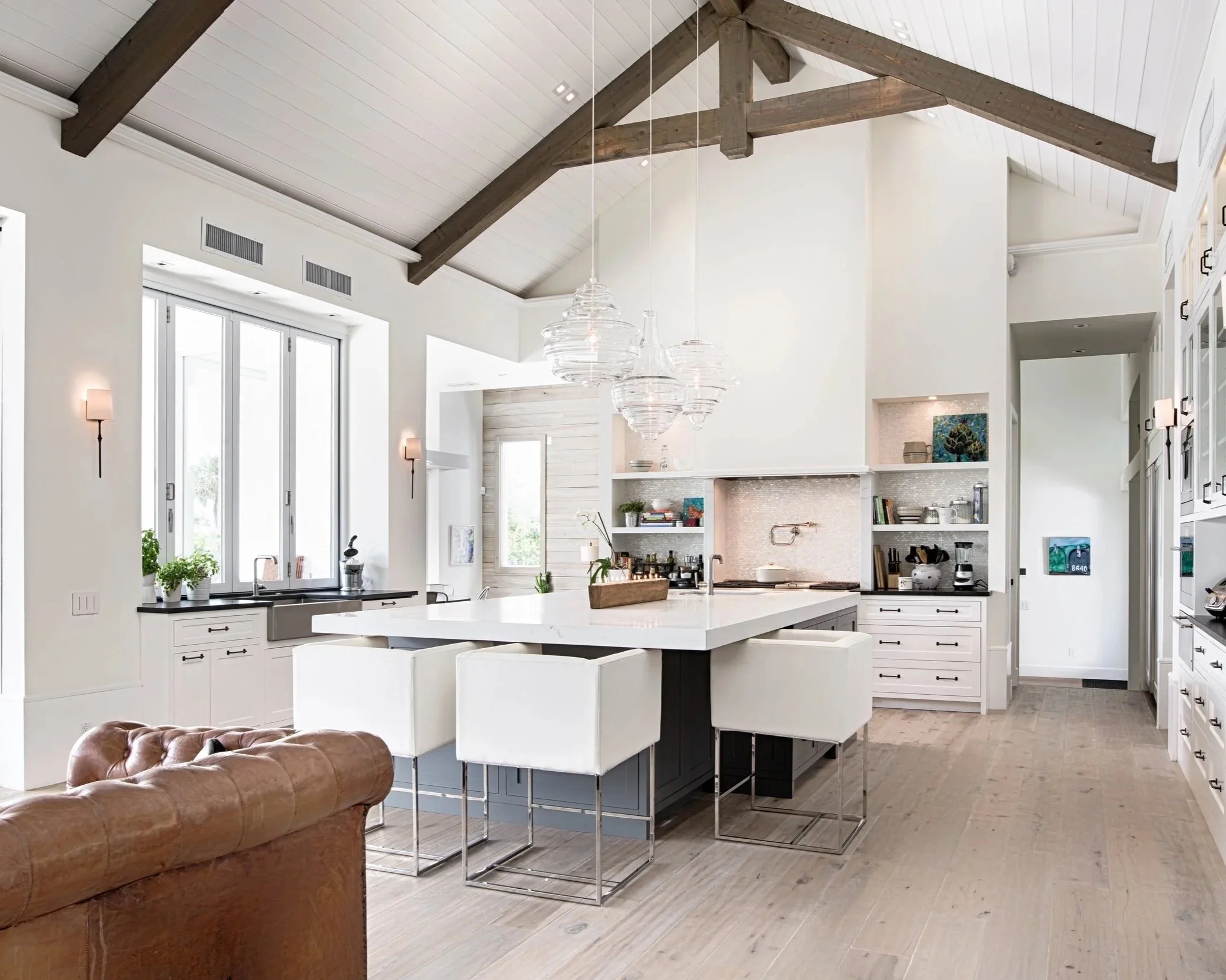 Bright modern kitchen with smart home technology, including automated lighting and appliances, in an open-concept living space