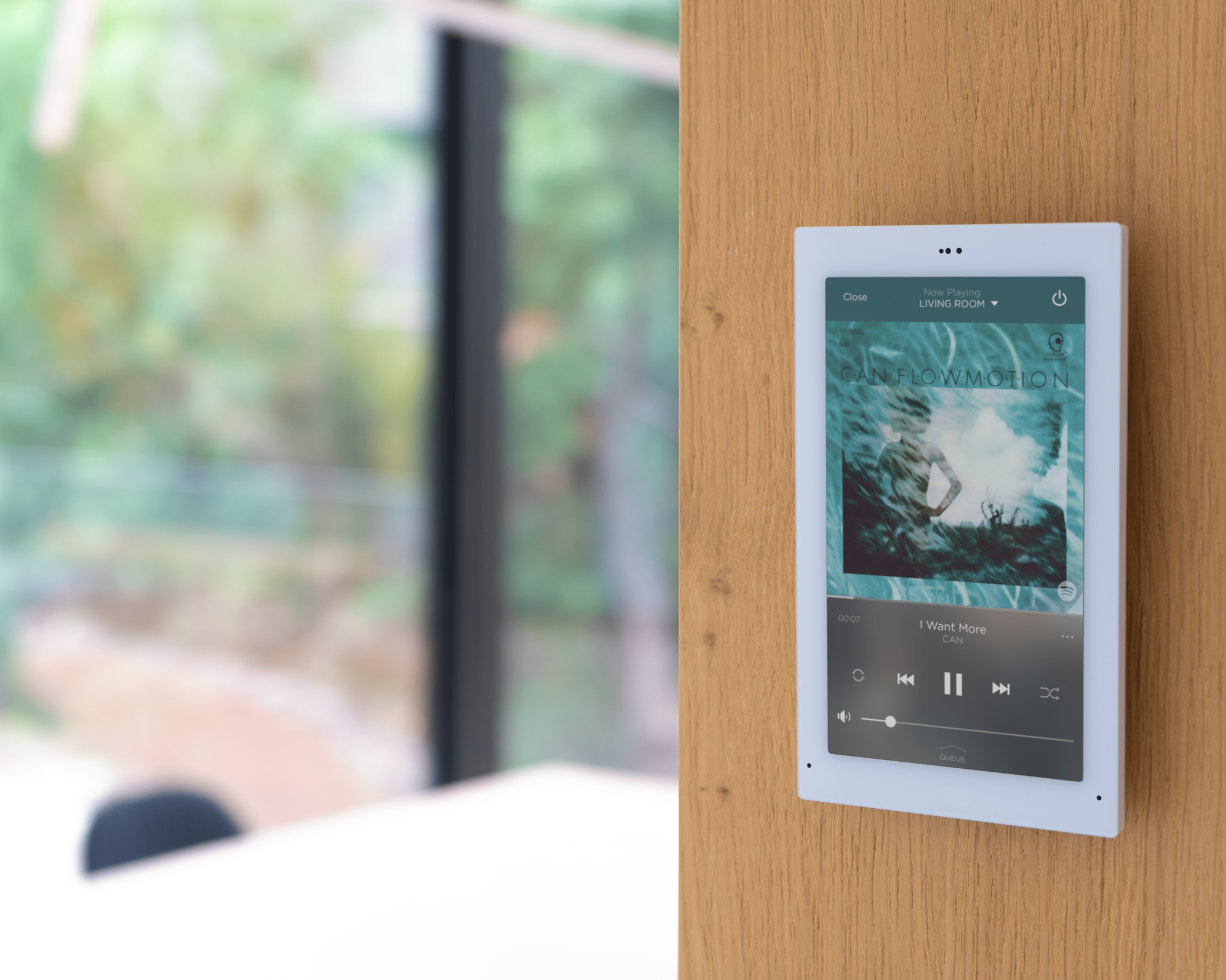 Wall-mounted smart home control panel displaying music playback as part of a whole-home audio system