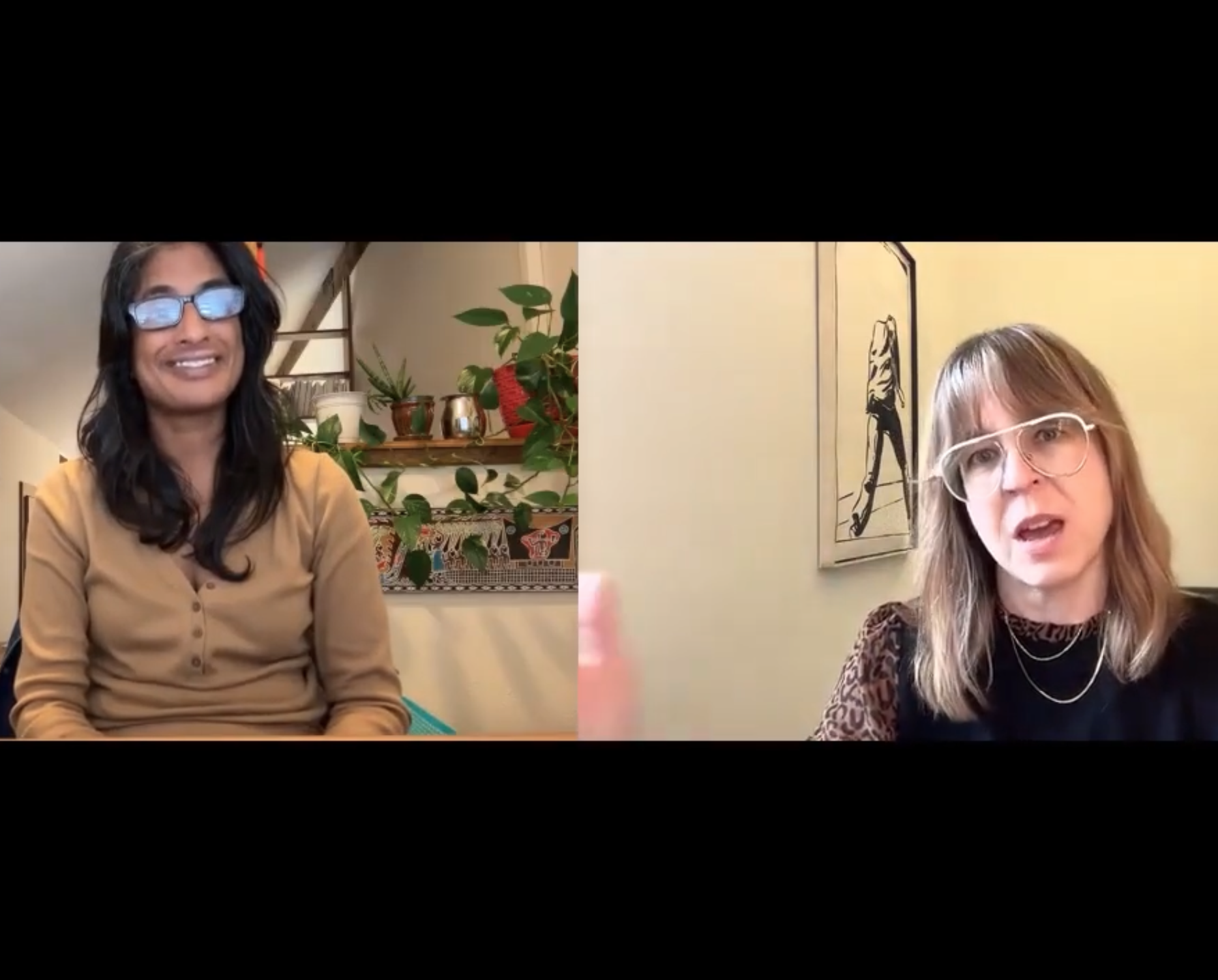 Two women having a video call: one with dark hair, glasses, beige top, smiling; the other with red hair, glasses, dark top, speaking.