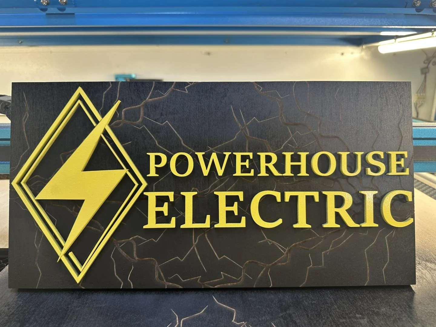 Black sign with yellow text and a yellow lightning bolt logo reading 'Powerhouse Electric'.