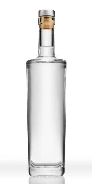 A clear glass bottle with a cork stopper against a plain white background.