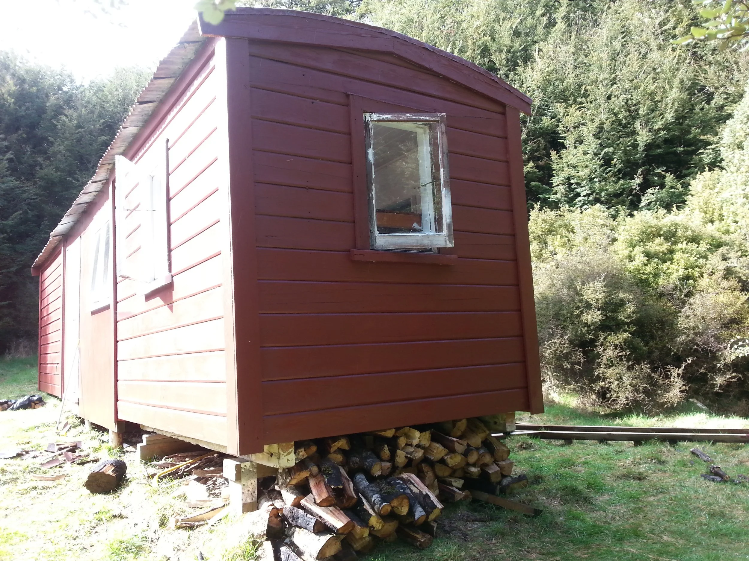 Outside of hut with wood pile.jpg