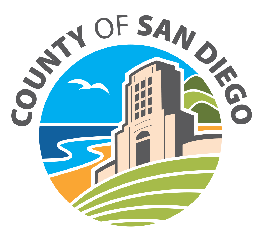 Emblem of the County of San Diego featuring a central building, ocean waves, a seagull, and green hills.