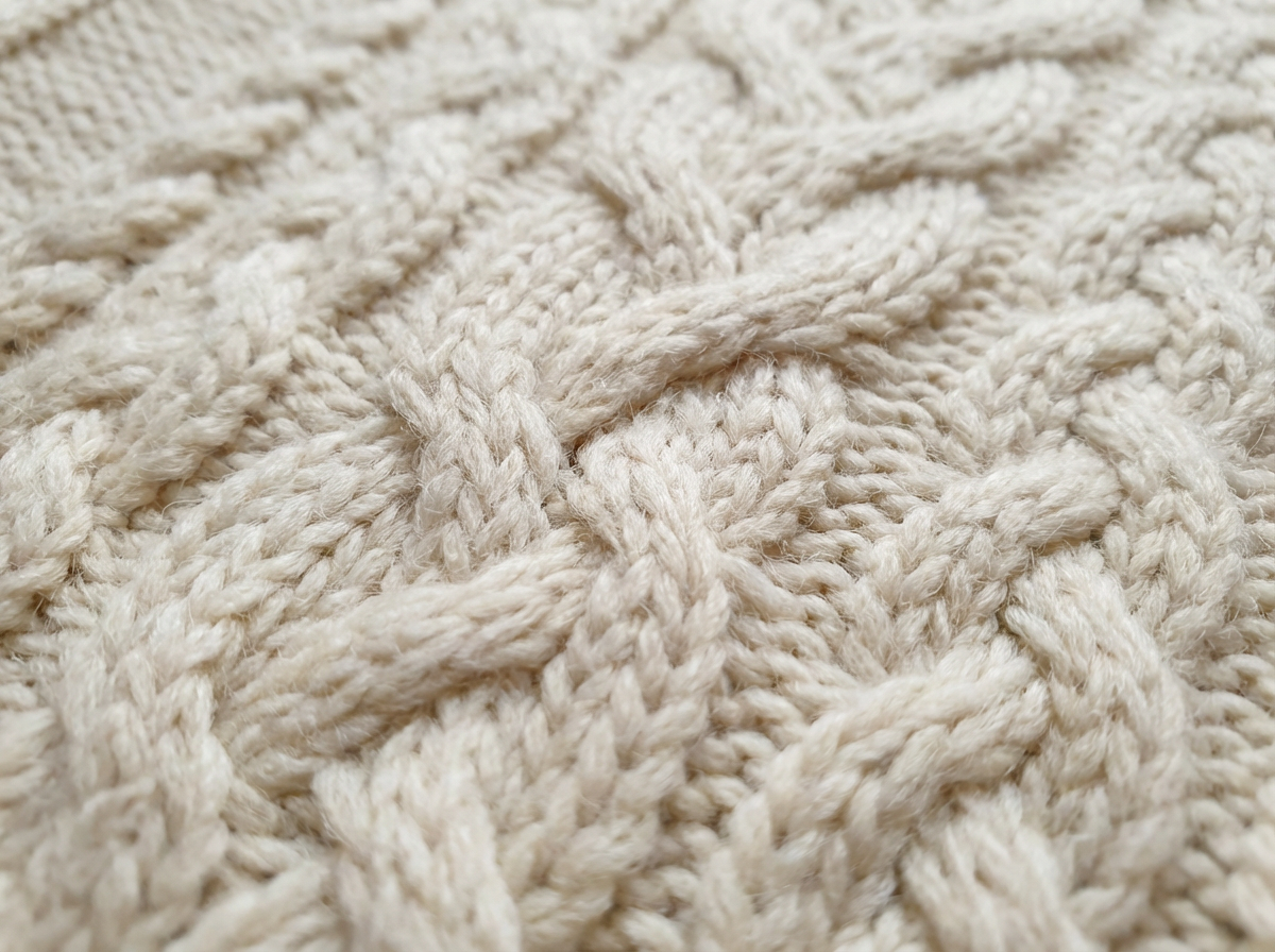 Cable knit sweater texture detail in cream wool
