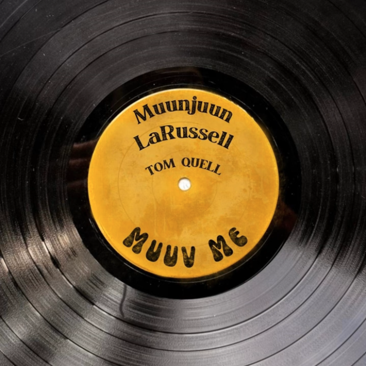Close-up of a black vinyl record with a yellow label in the center listing song titles and artist names- Muunjuun, LaRussell and Tom Quell
