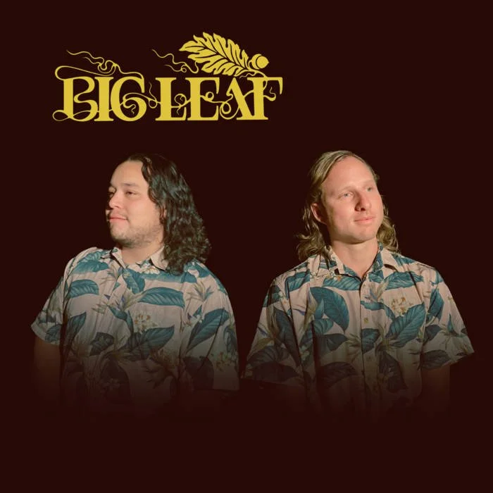 Two men with long hair wearing matching tropical shirts, standing side by side against a dark background, with the word "BIG LEAF" and a leaf graphic above them.