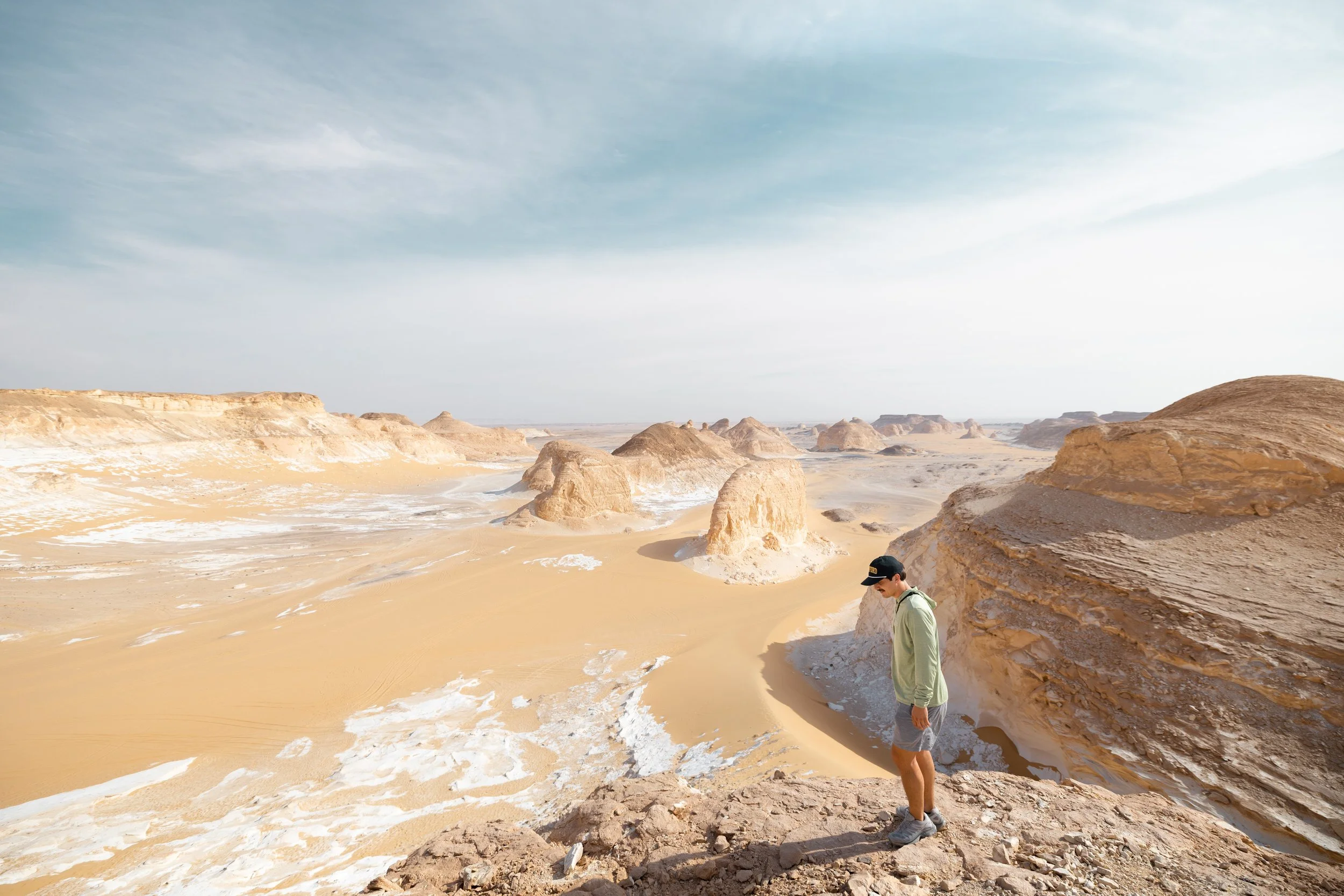 Standing at the edge of the White Desert in Egypt, looking out over chalk rock formations and sandy valleys.
