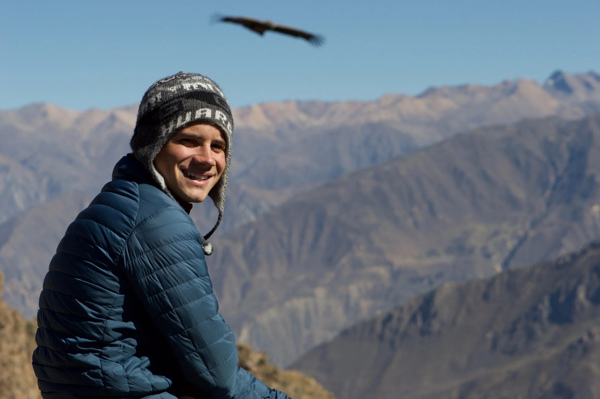 Sergio overlooking Colca Canyon in Peru with an Andean condor flying in the background