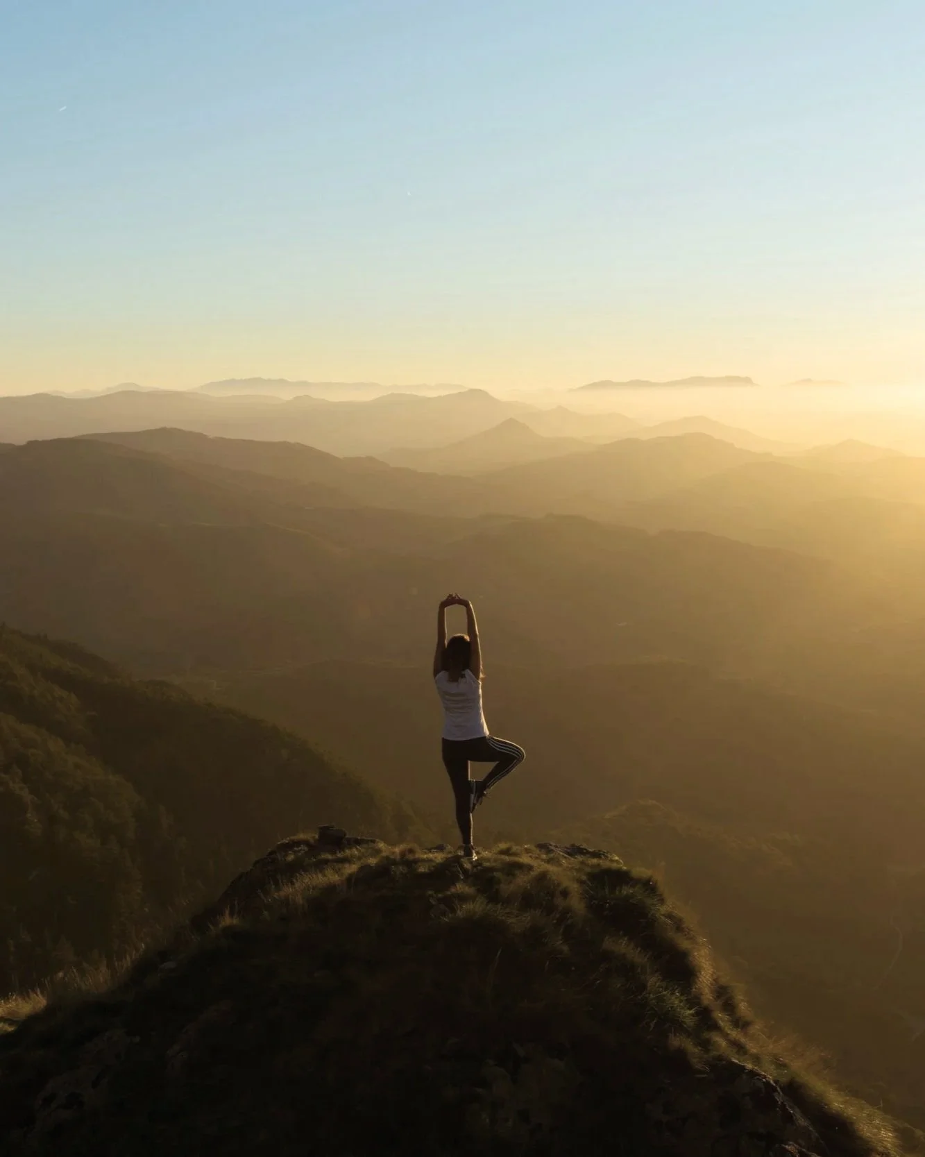 woman practicing yoga on mountain for wellness and cultural travel in Asia