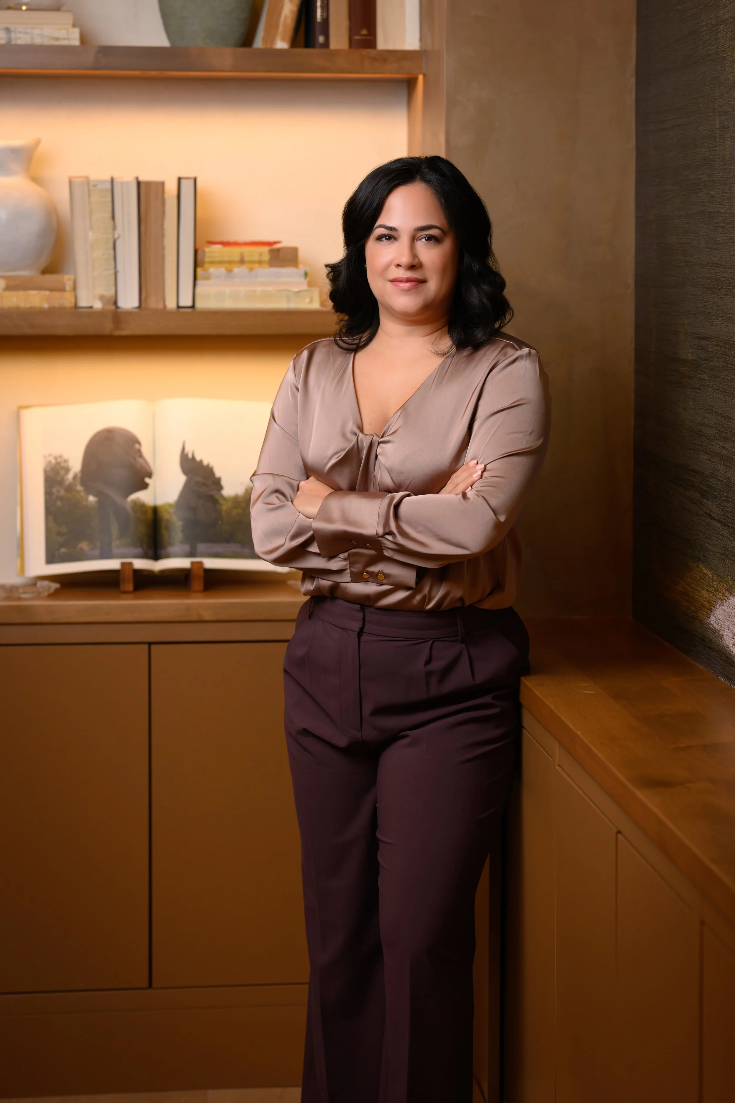 Sheila crosses her arms in a mauve and maroon outfit