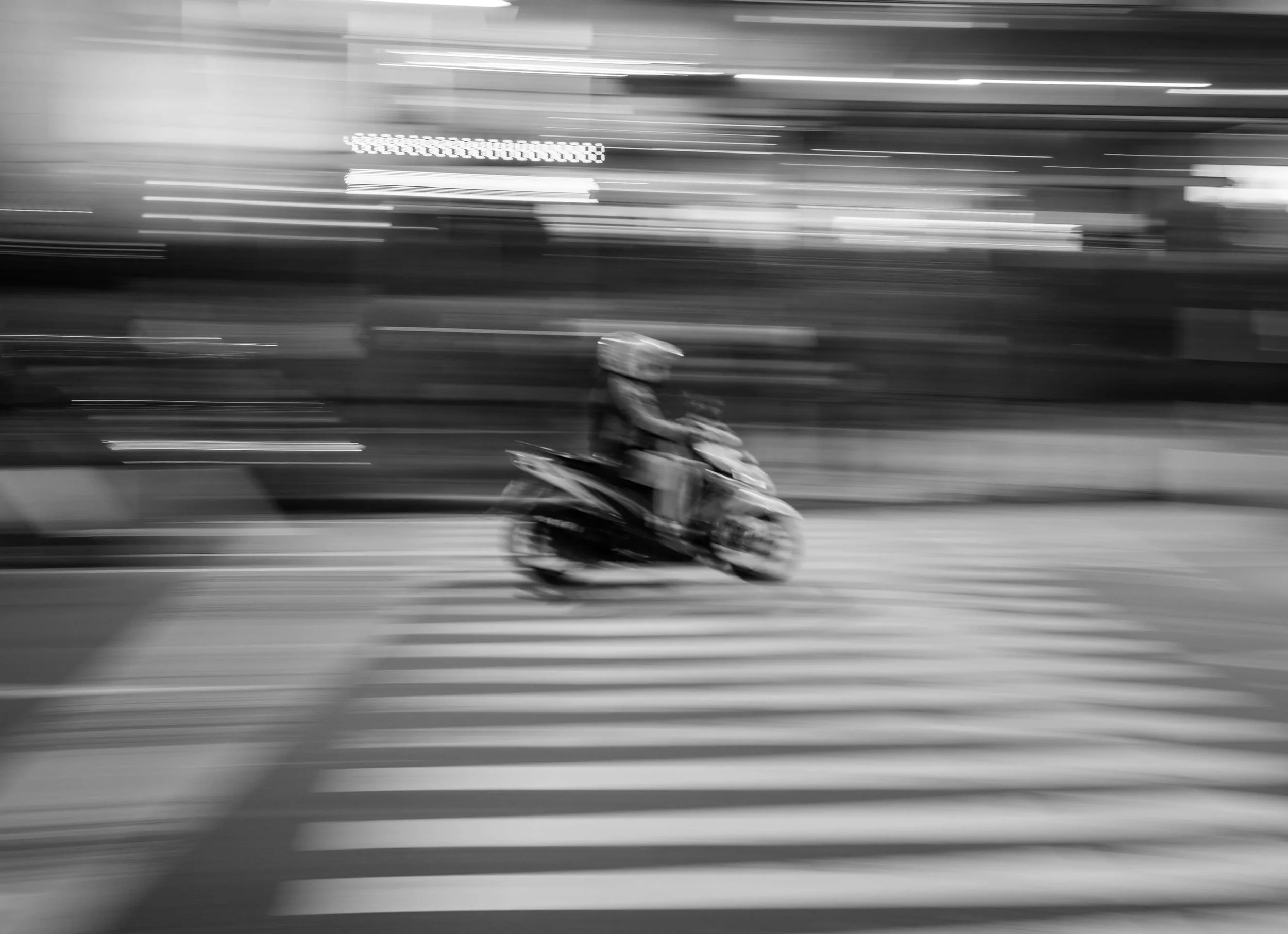 A motion blur photo of a motorcycle in black and white