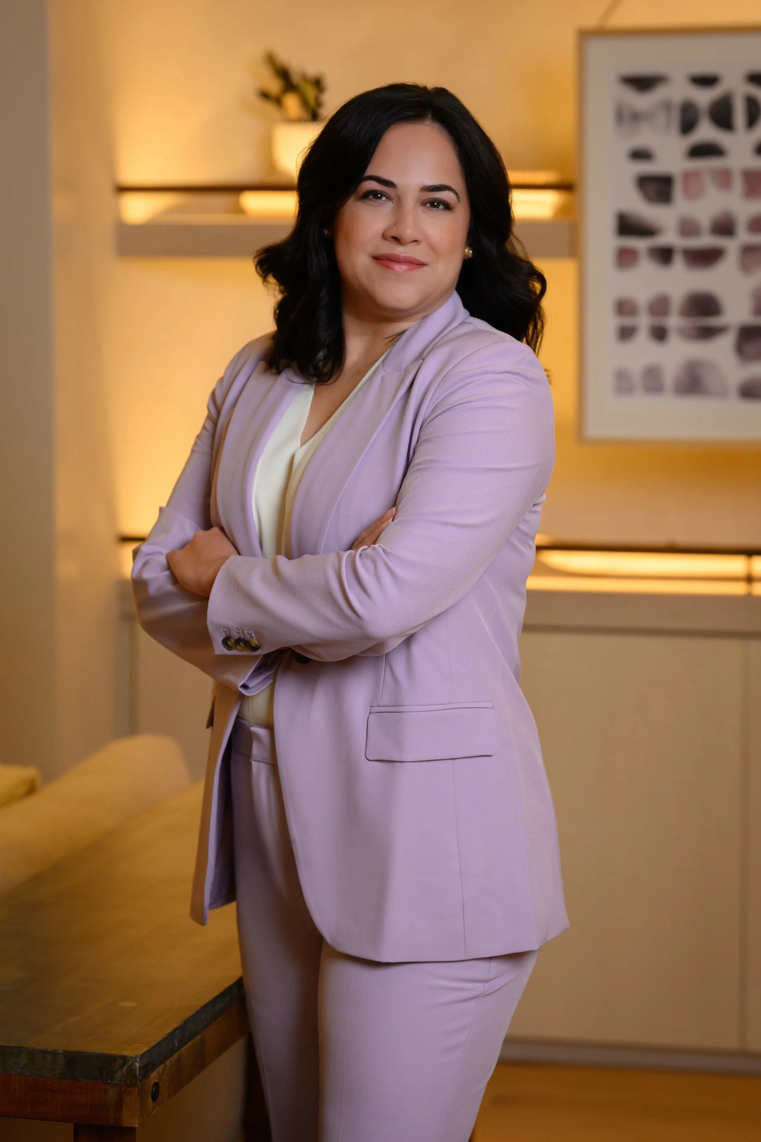 Sheila hands with arms crossed in a lavender pantsuit