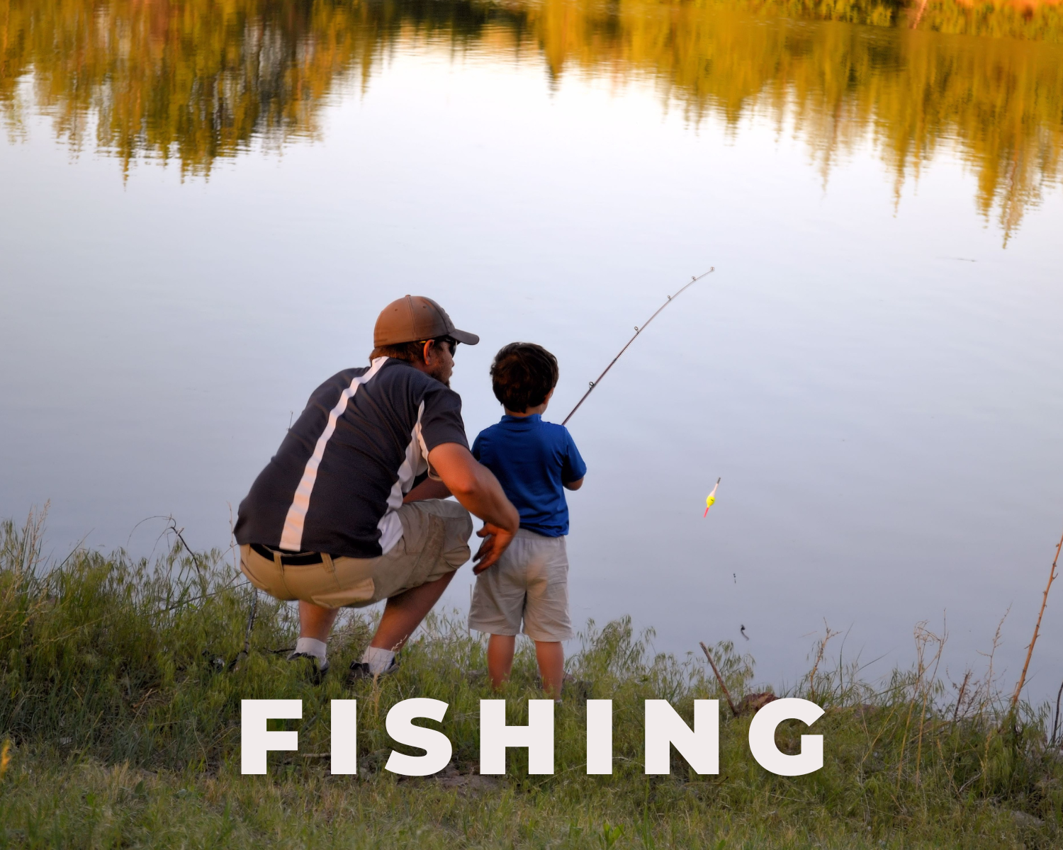 A man and a boy fishing by a lake during sunset. The man is squatting behind the boy, who is holding a fishing rod over the water. The word 'FISHING' is written in large white letters at the bottom of the image.