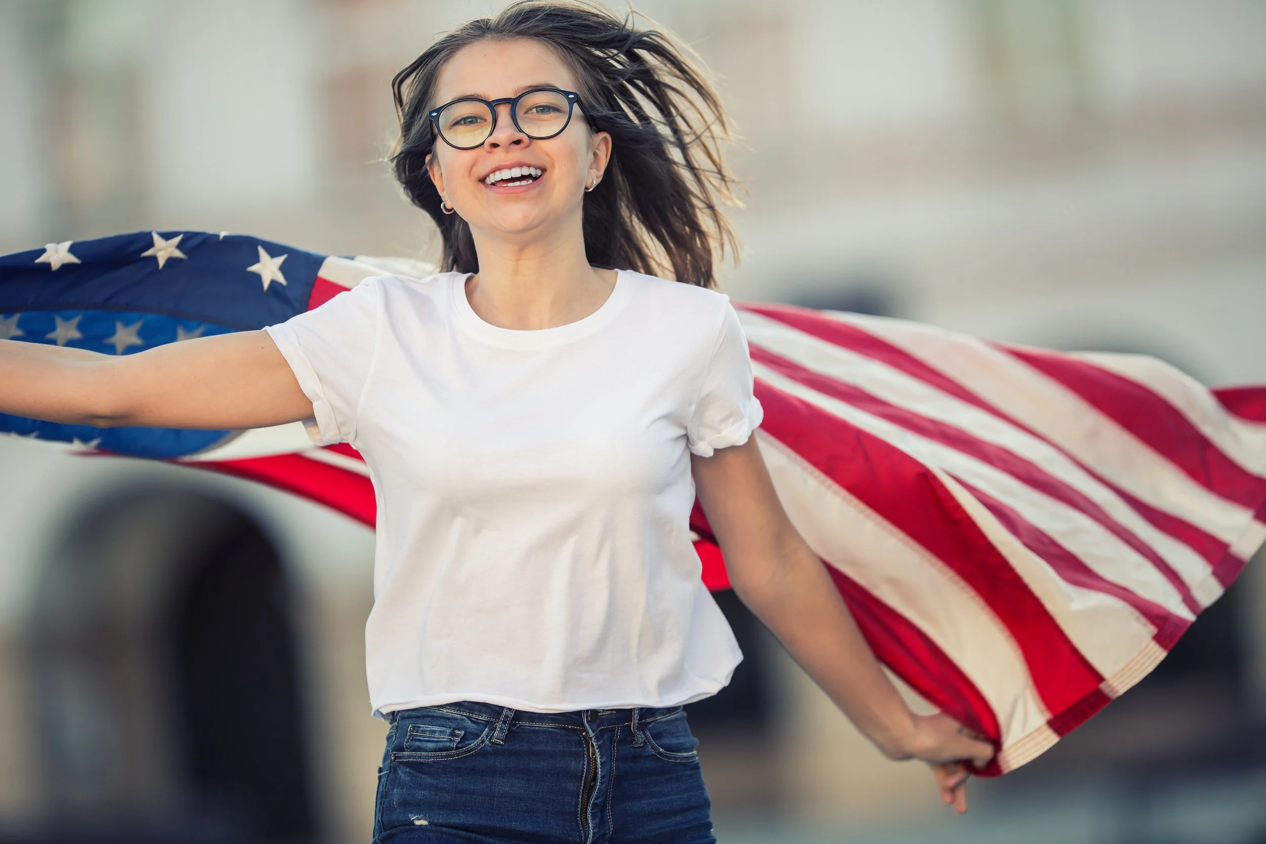 happy-young-american-school-girl-holding-waving-city-with-usa-flag.jpg