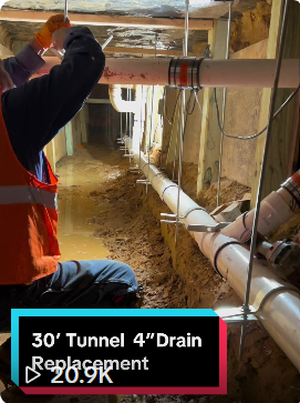 Commercial main sewer line replacement and 30-foot under-slab excavation tunnel beneath a school building foundation.